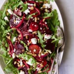 Photo of Roasted Beet Salad with Walnuts Goat Cheese and Honey Balsamic Dressing on white oval platter.