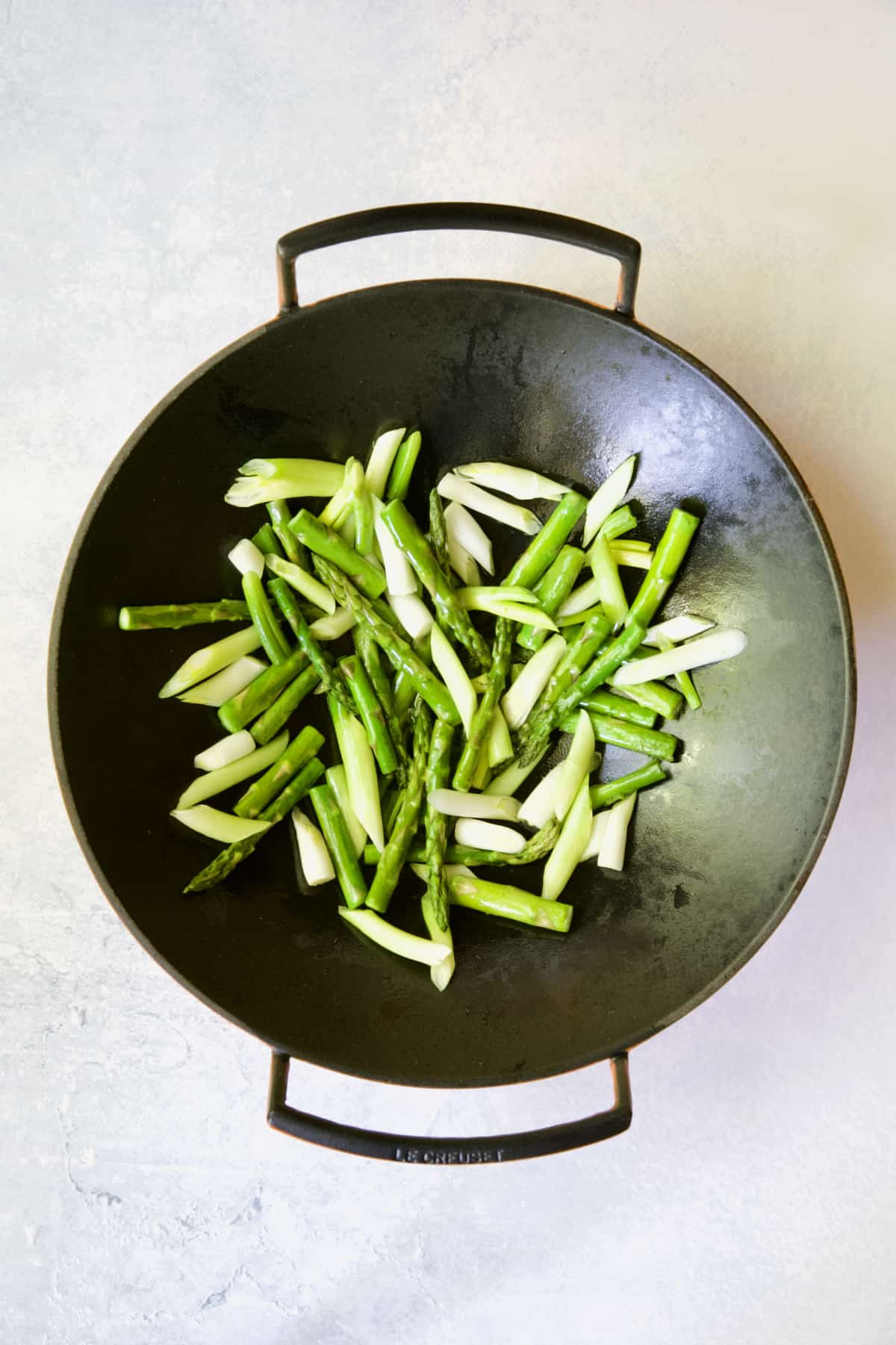 Asparagus and scallions in cast iron wok.