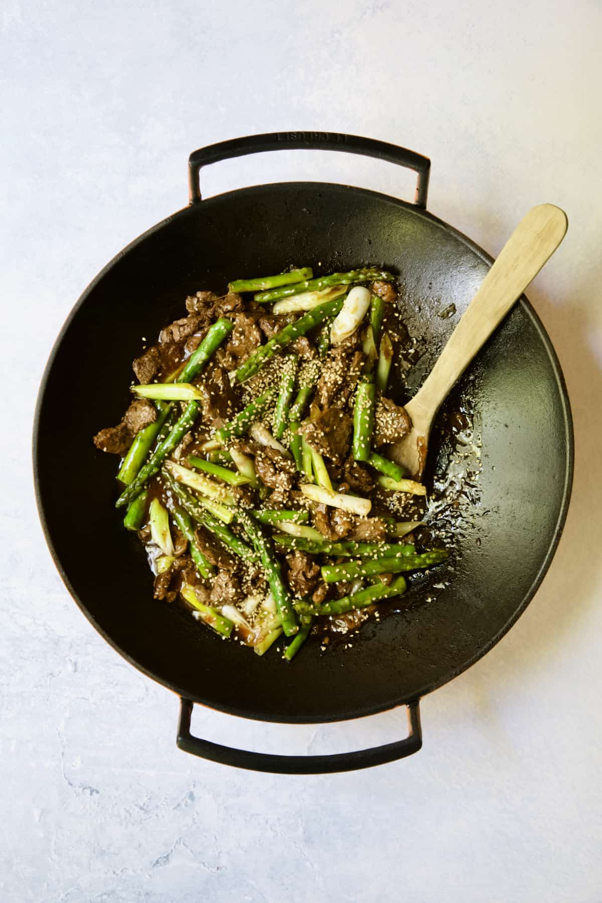 Sesame Beef and Asparagus Stir-Fry being stirred with wooden spoon.