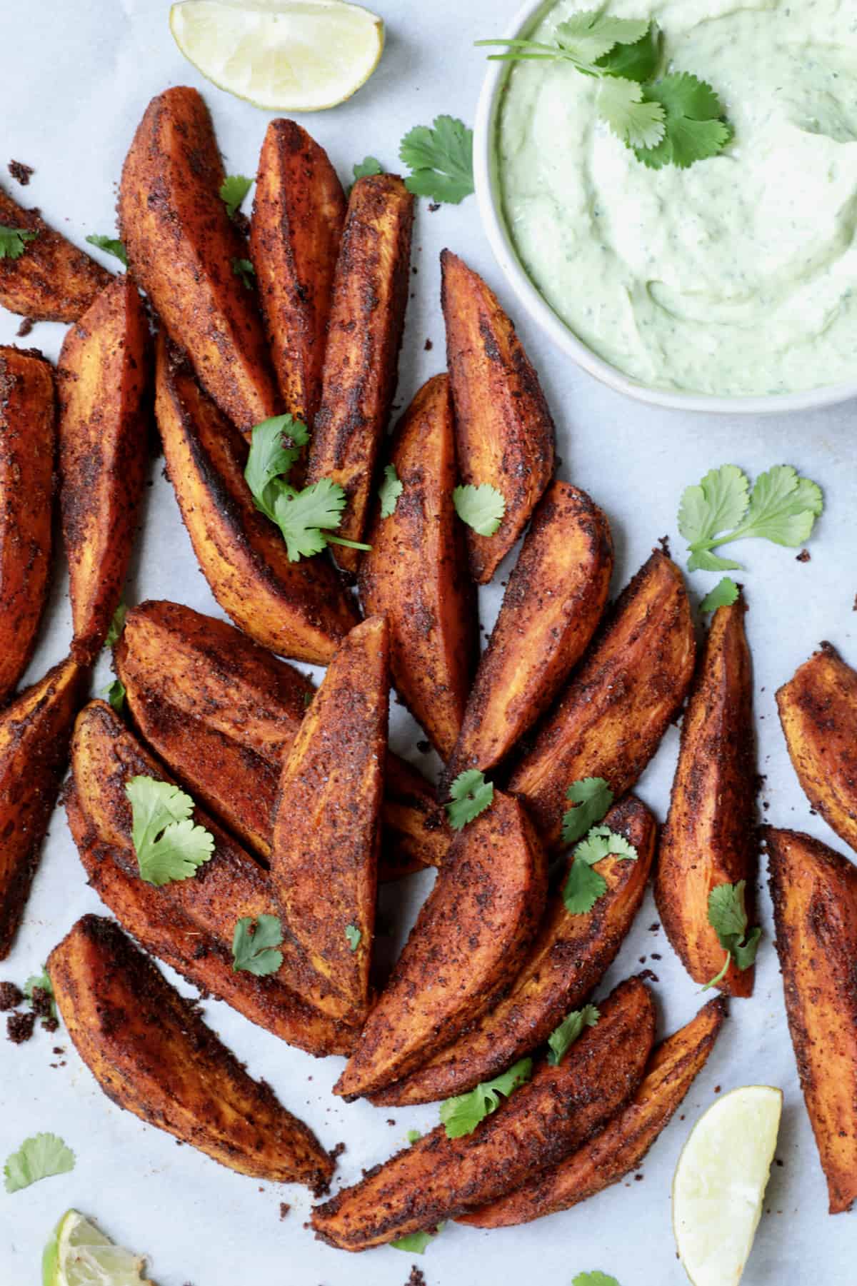 Southwestern Sweet Potato Wedges with Avocado - Cilantro Sour Cream garnished with cilantro.