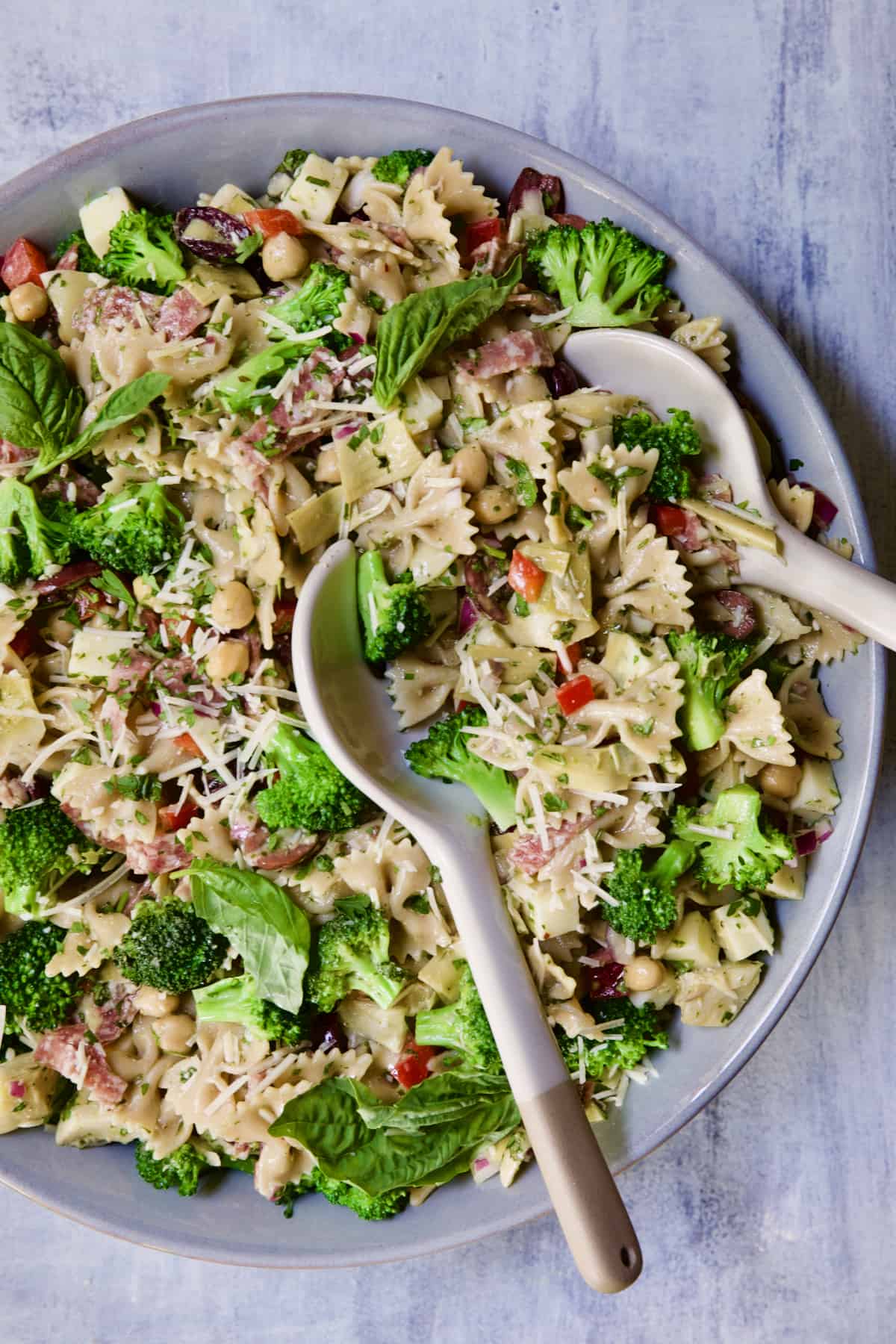 Antipasto Pasta Salad with Parmesan Herb Vinaigrette garnished with fresh basil.
