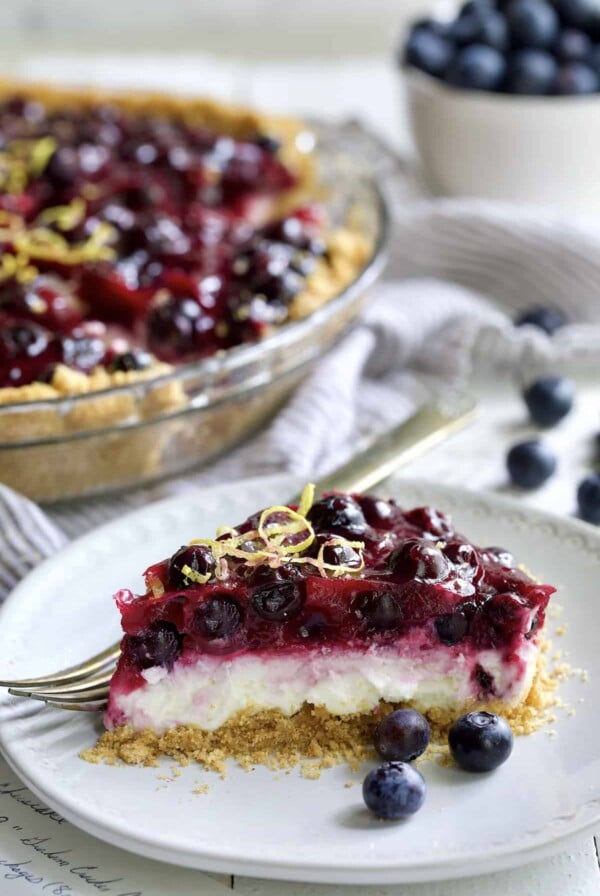 Photo of a slice of Blueberry Cream Cheese Pie on a white plate.