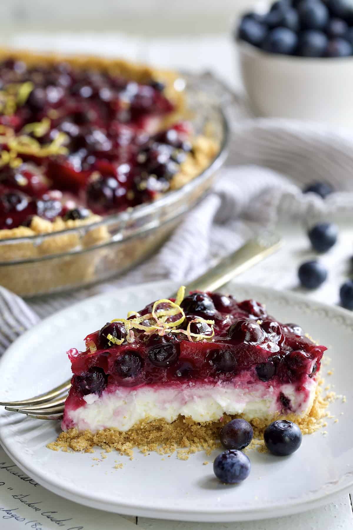Photo of a slice of Blueberry Cream Cheese Pie on a white plate.