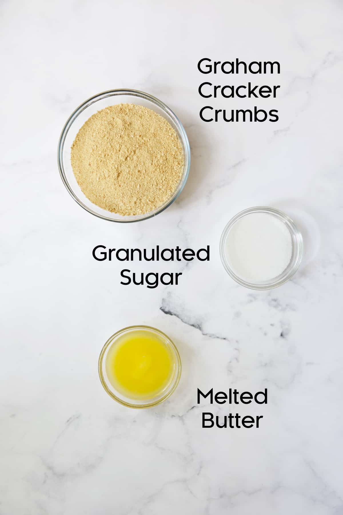 Photo of ingredients for graham cracker crust in glass bowls.