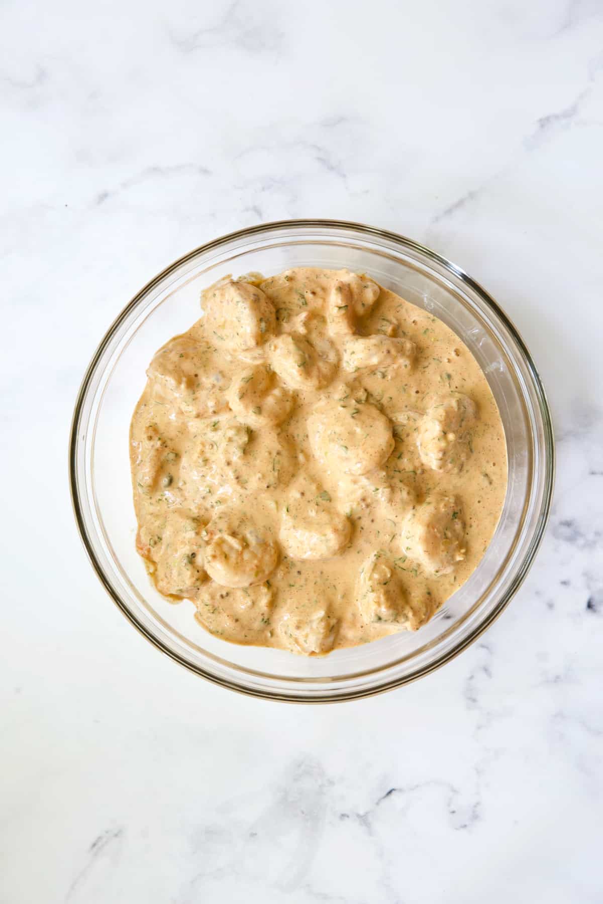 Shrimp in Sriracha Remoulade in glass bowl.