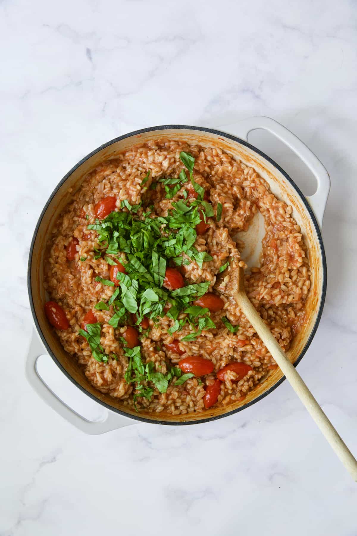 Process photo of farro risotto after basil is added.