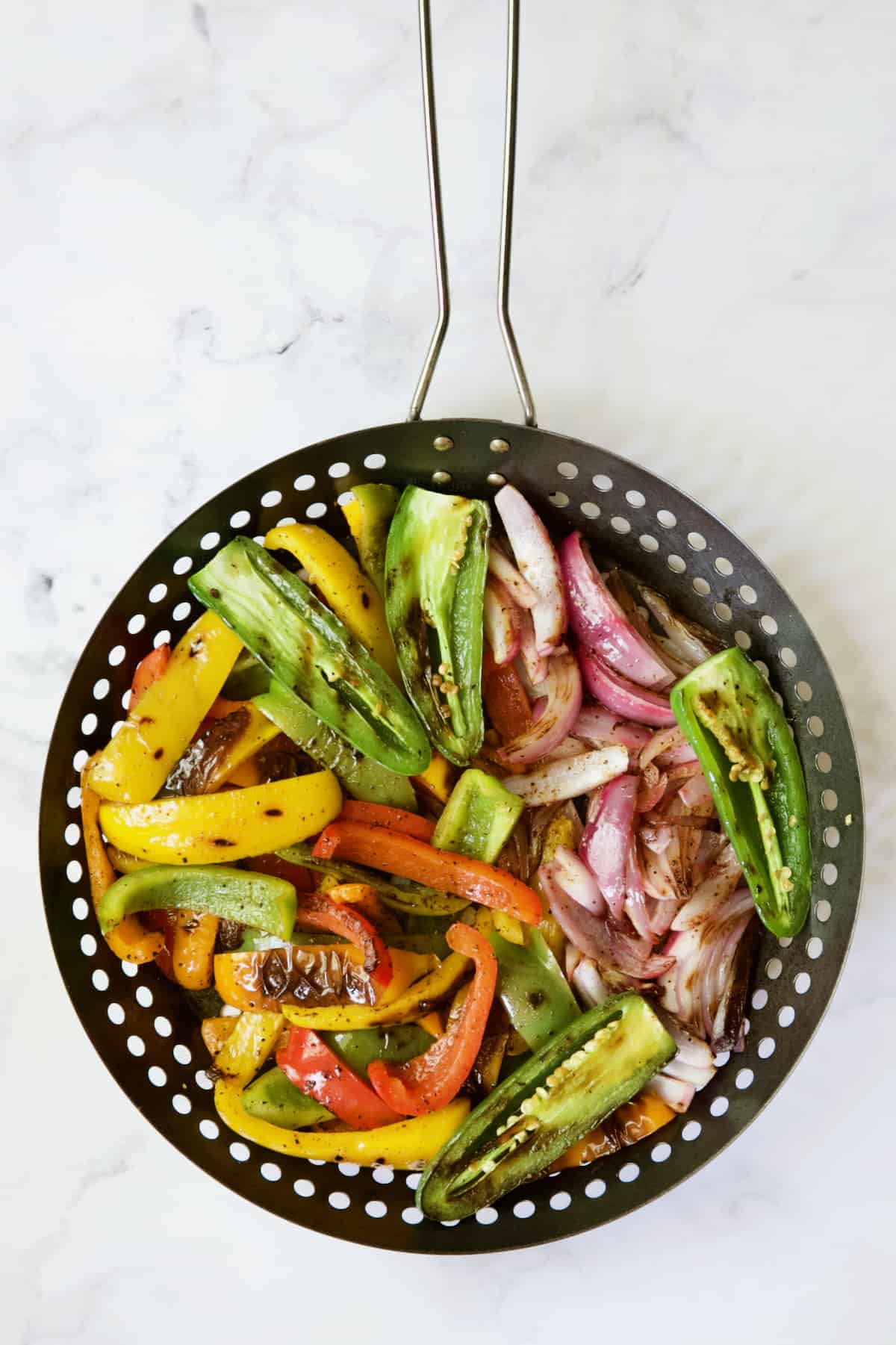 Vegetables for Grilled Tajin-Seasoned Chicken Fajitas in grill basket after grilling.