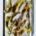Fully roasted Hatch green chiles on rimmed sheet pan.