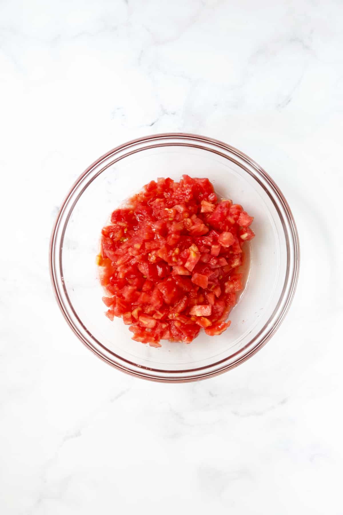 Diced tomatoes in glass bowl.