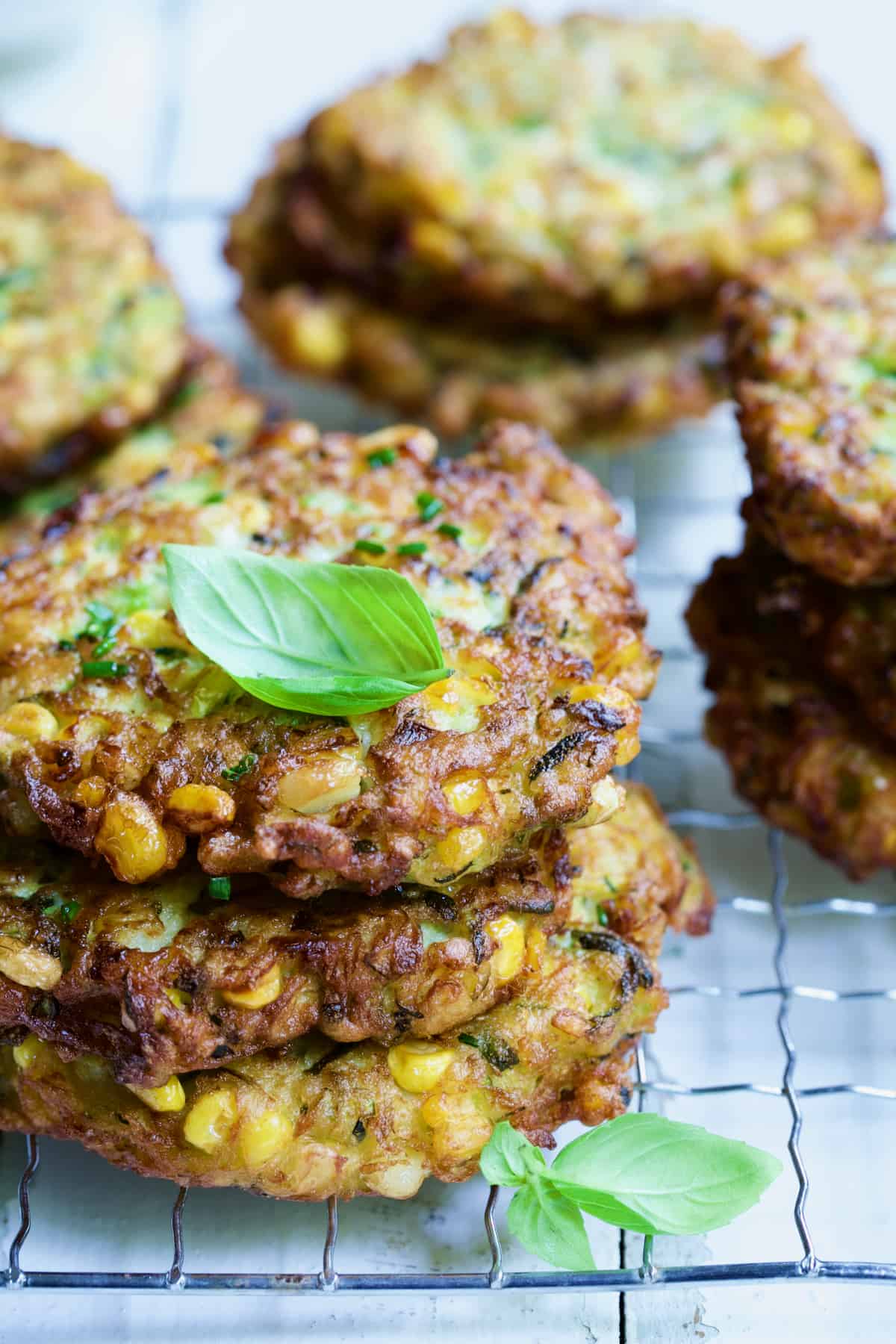 Stack of three Zucchini Corn Cakes with more in the background.