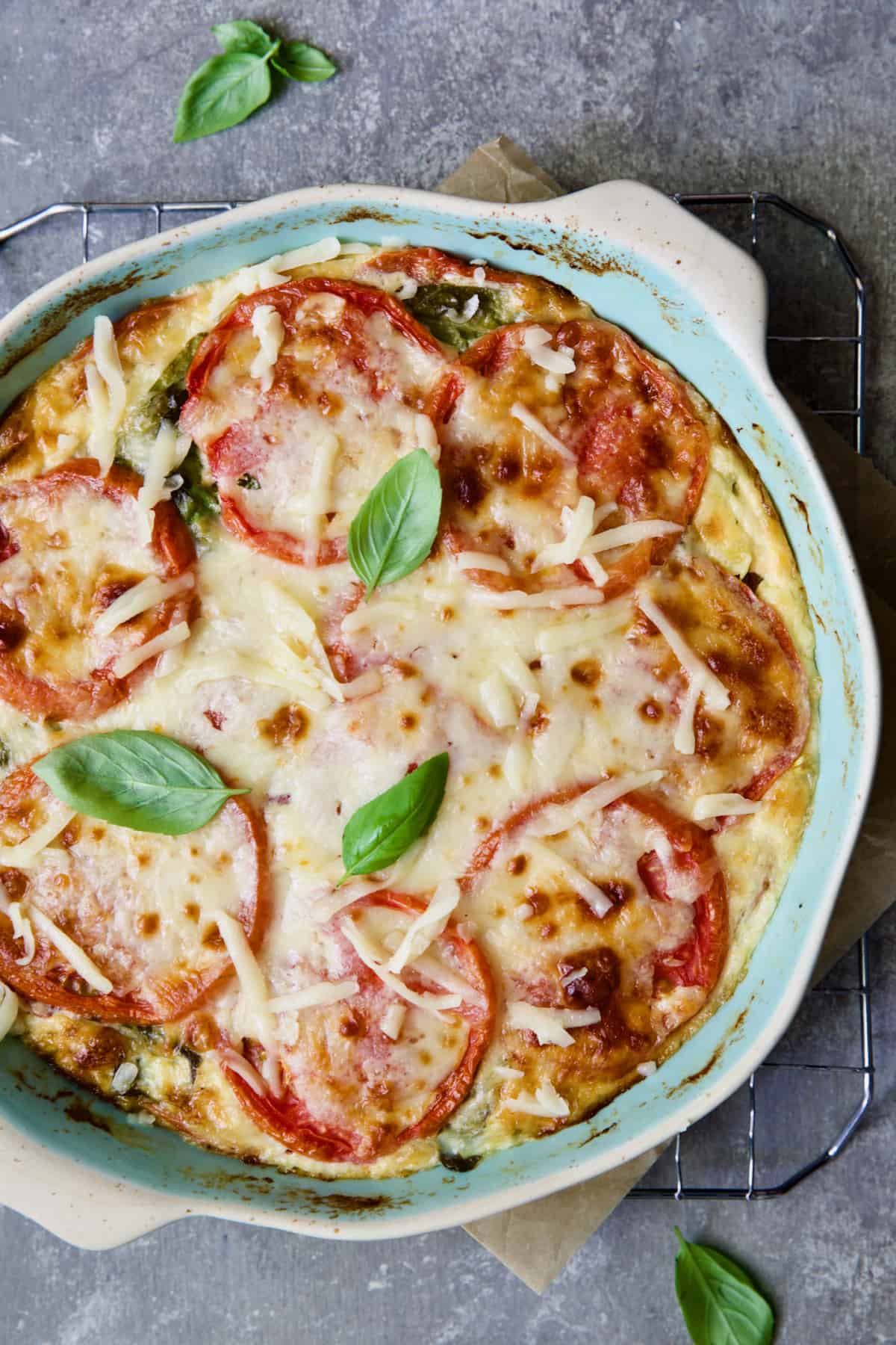 Crustless Southern Tomato Pie in light blue pie pan after being baked.