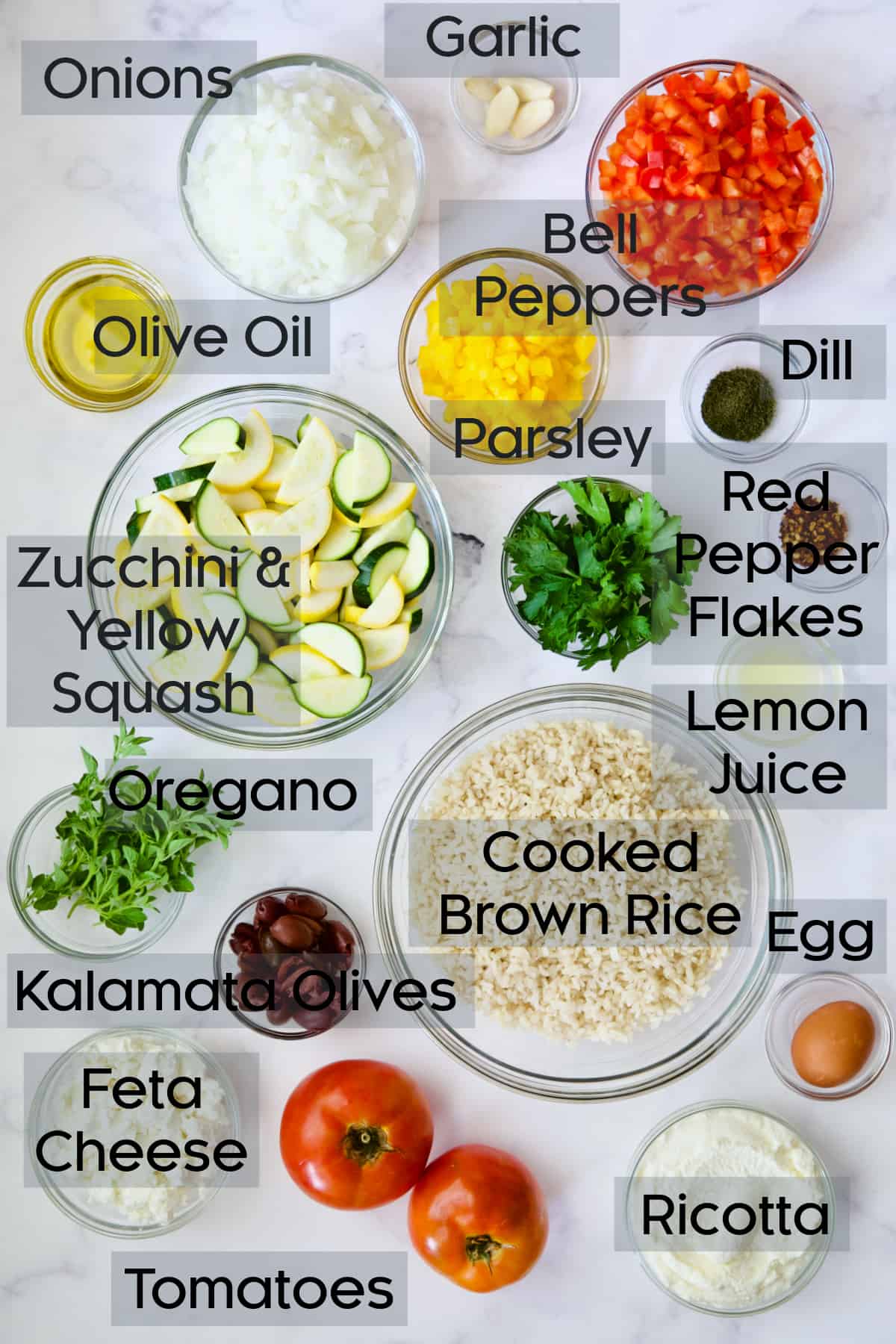 Ingredients for Greek Brown Rice and Vegetable Casserole in glass bowls.