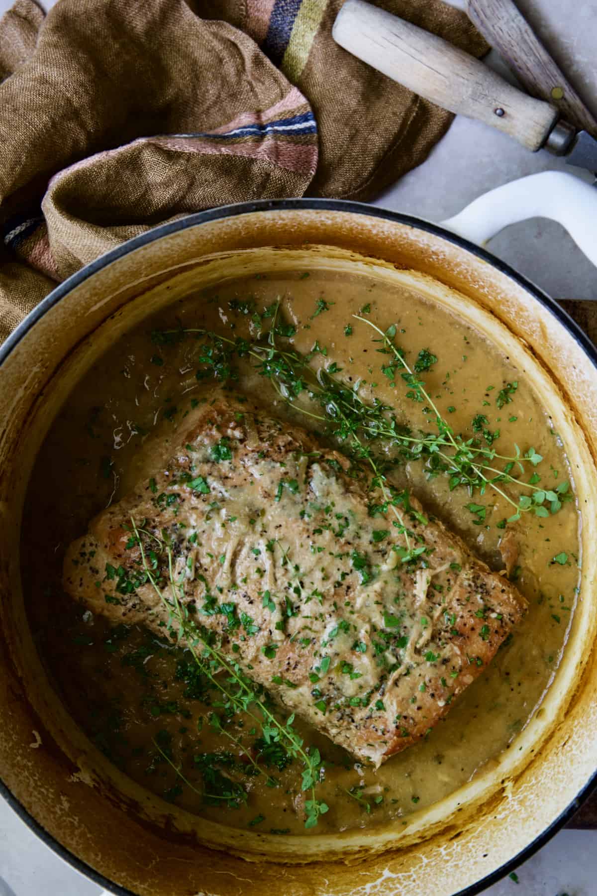 Braised Pork Loin Roast in Dijon Mustard Sauce in white Dutch oven.