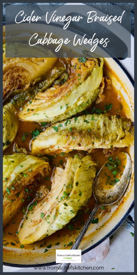 Six braised cabbage wedges in white enamel cast iron skillet.