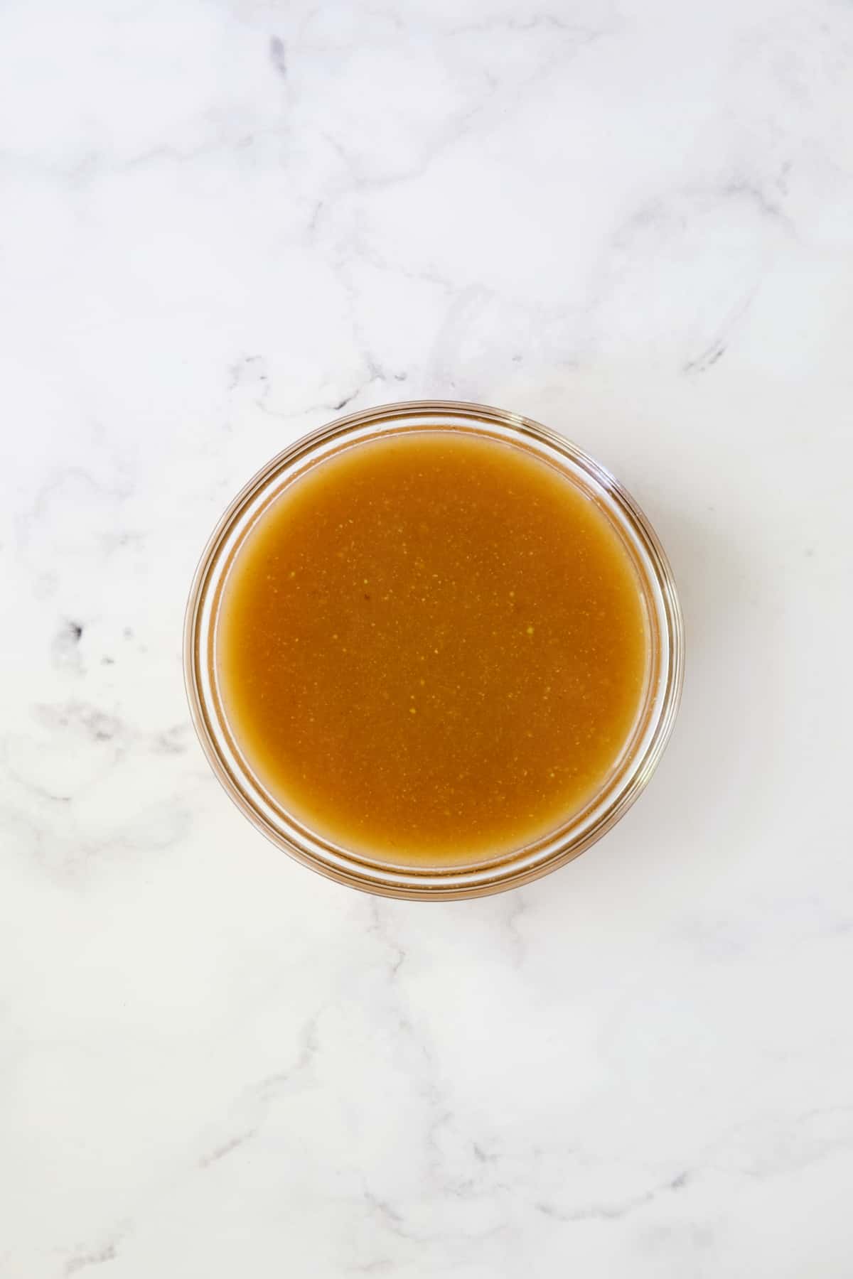 Sauce for cabbage in glass bowl before being cooked.