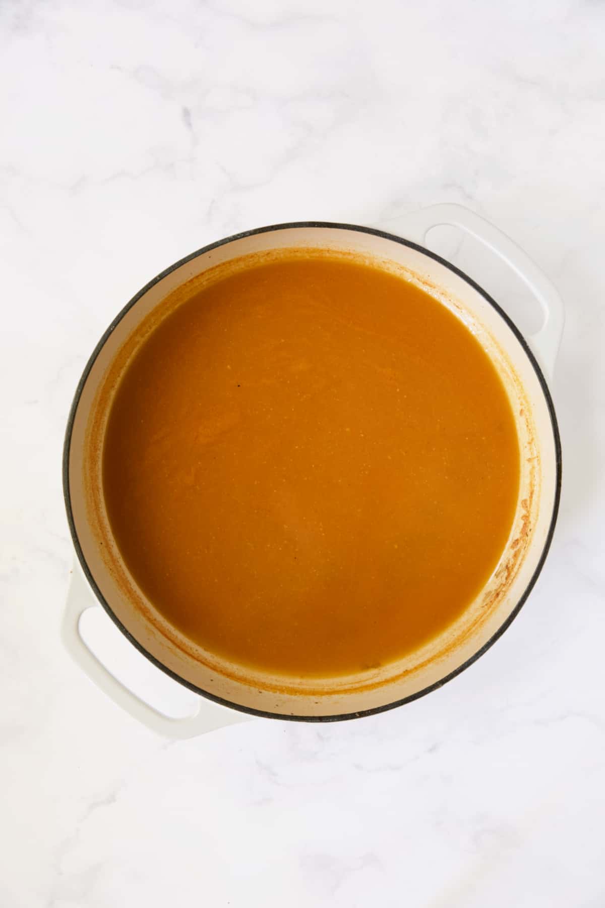Sauce for cabbage in white enamel cast iron skillet after being reduced.