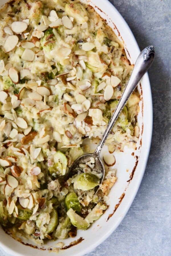 Cheesy Brussels Sprouts and Wild Rice Casserole in oval gratin dish with serving removed.