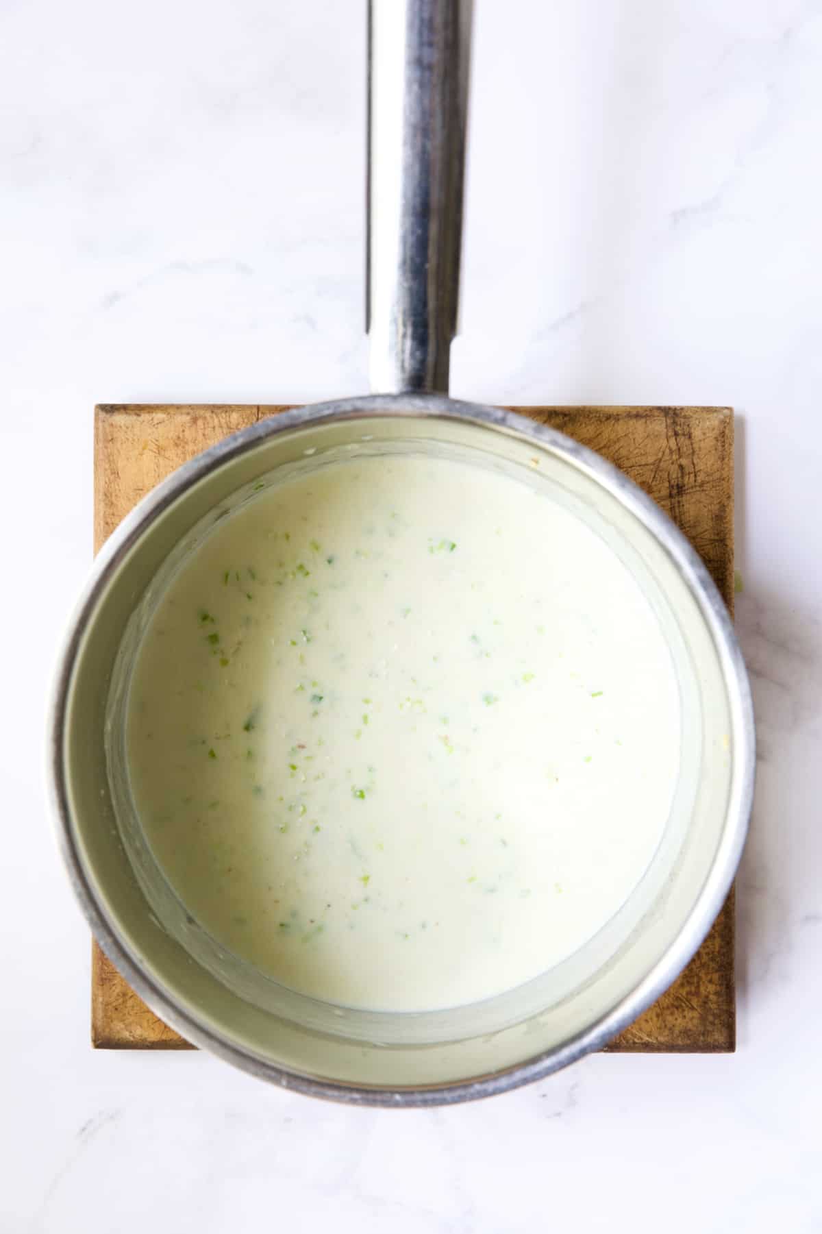 White sauce in stainless steel saucepan.