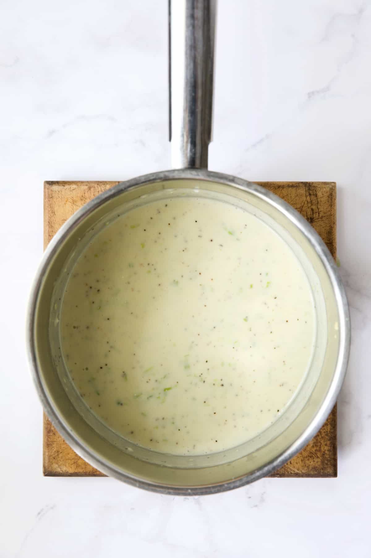 Cheese sauce in stainless steel saucepan.