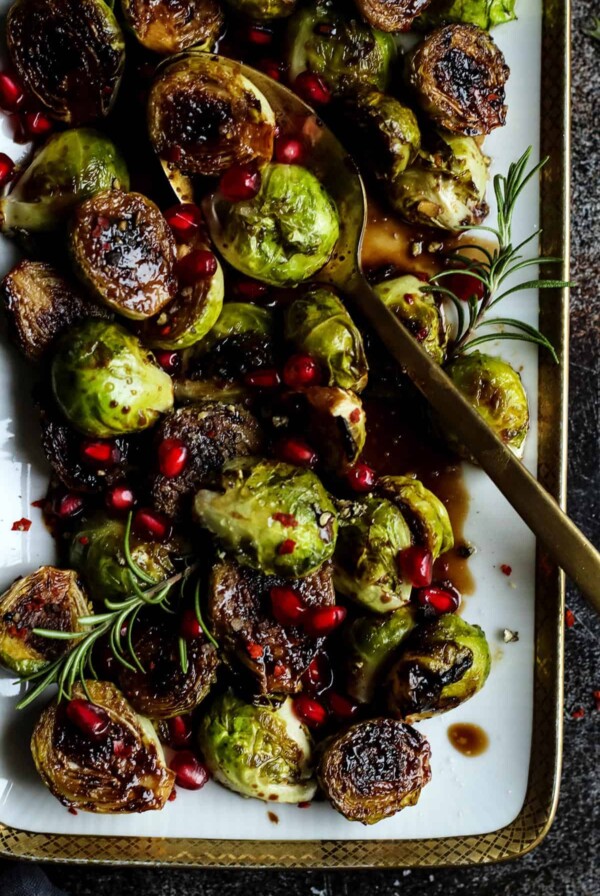 Pan-Seared Brussels Sprouts garnished with rosemary and pomegranate arils.