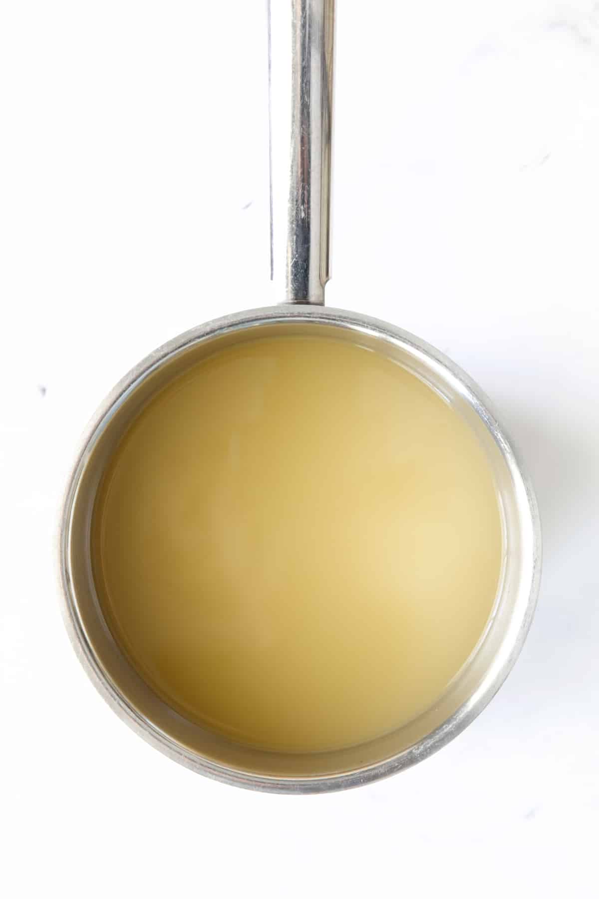 Chicken broth in stainless steel saucepan.