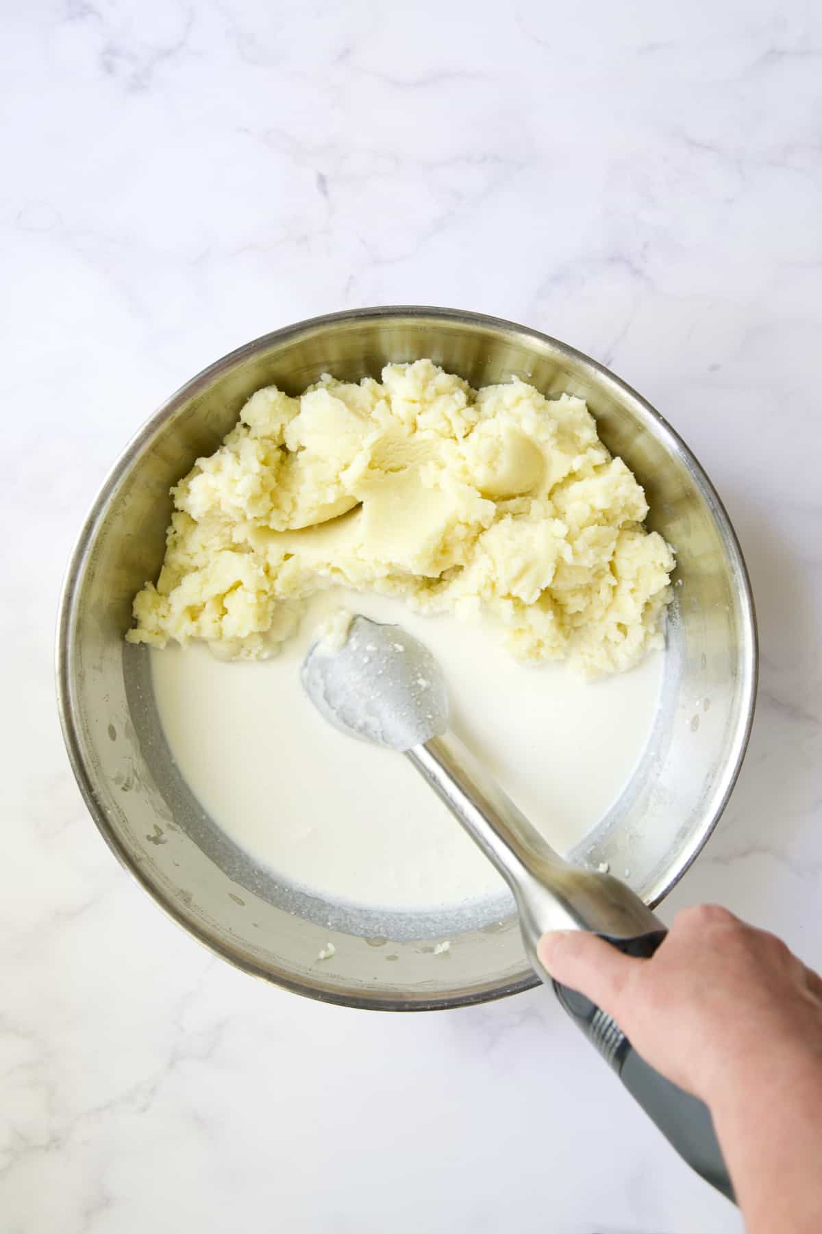 Immersion blender smoothing out cream cheese, sour cream and half-and-half.