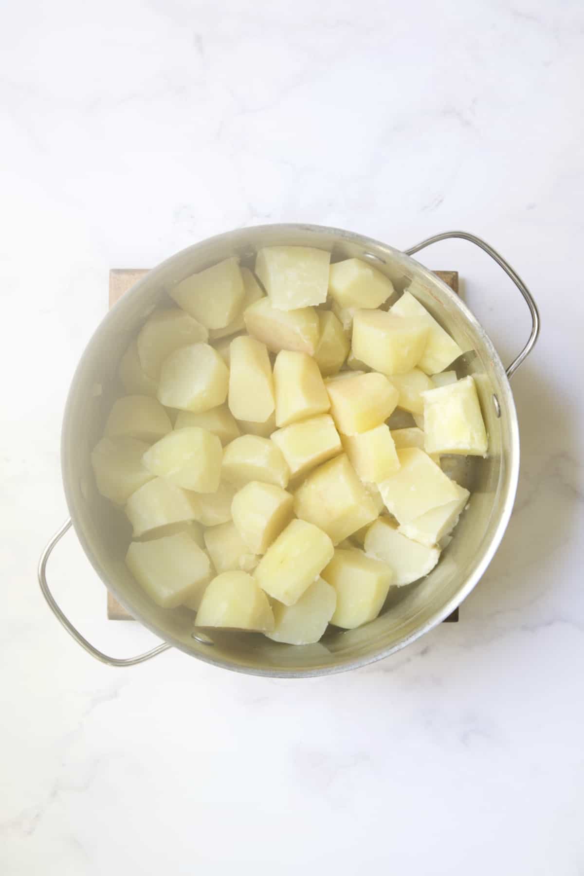 Cooked potatoes in pot still steaming.