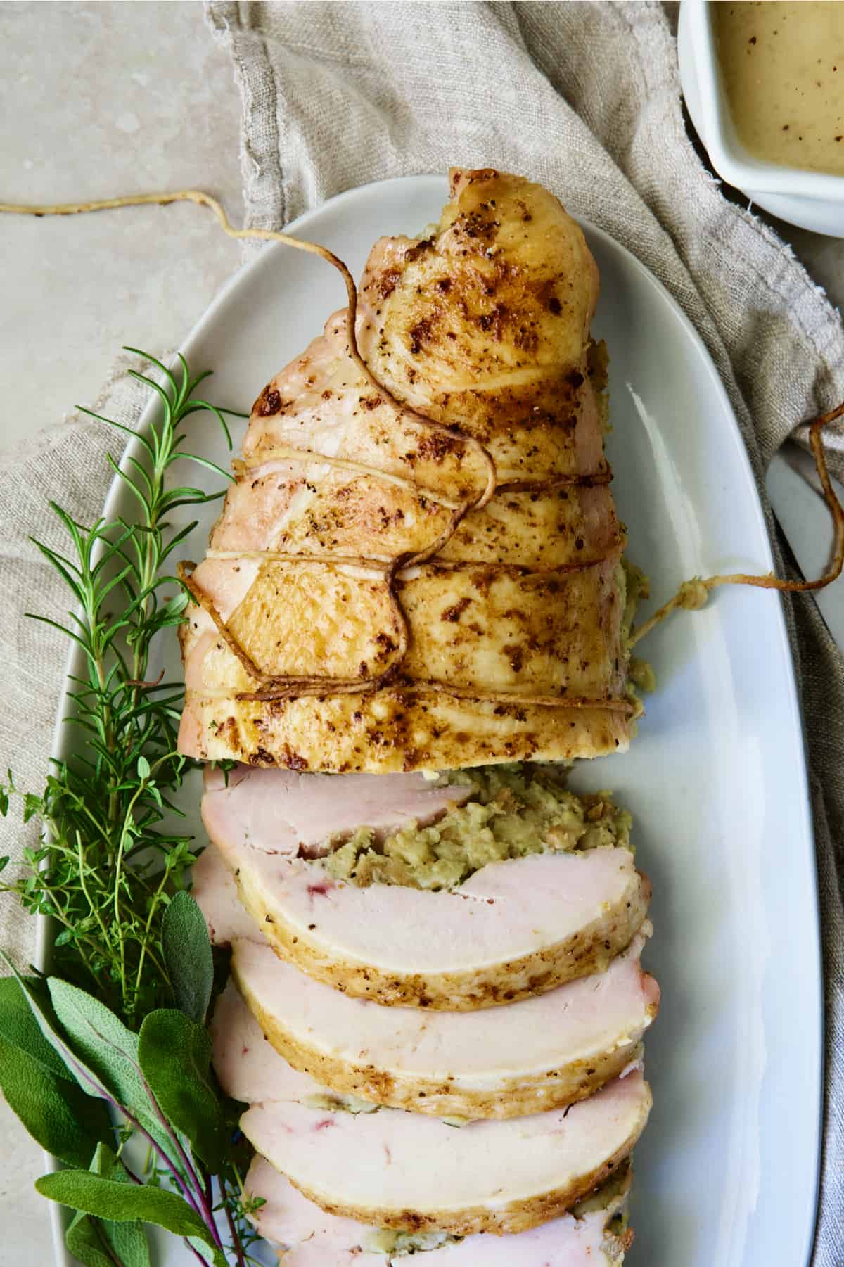 Roast Turkey Breast with Traditional Stuffing garnished with fresh herbs.