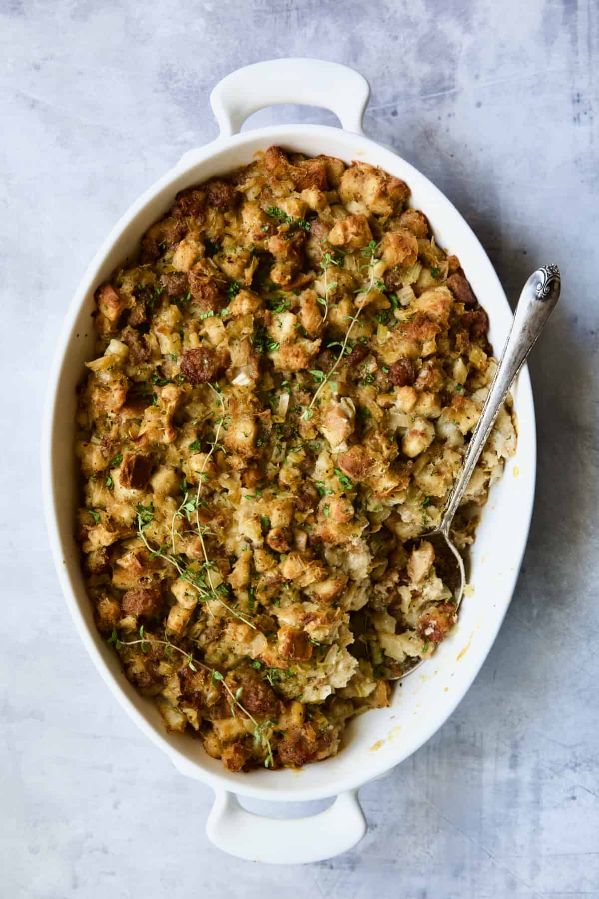 Sausage Stuffing with Fennel and Leeks in white oval gratin dish after being baked.