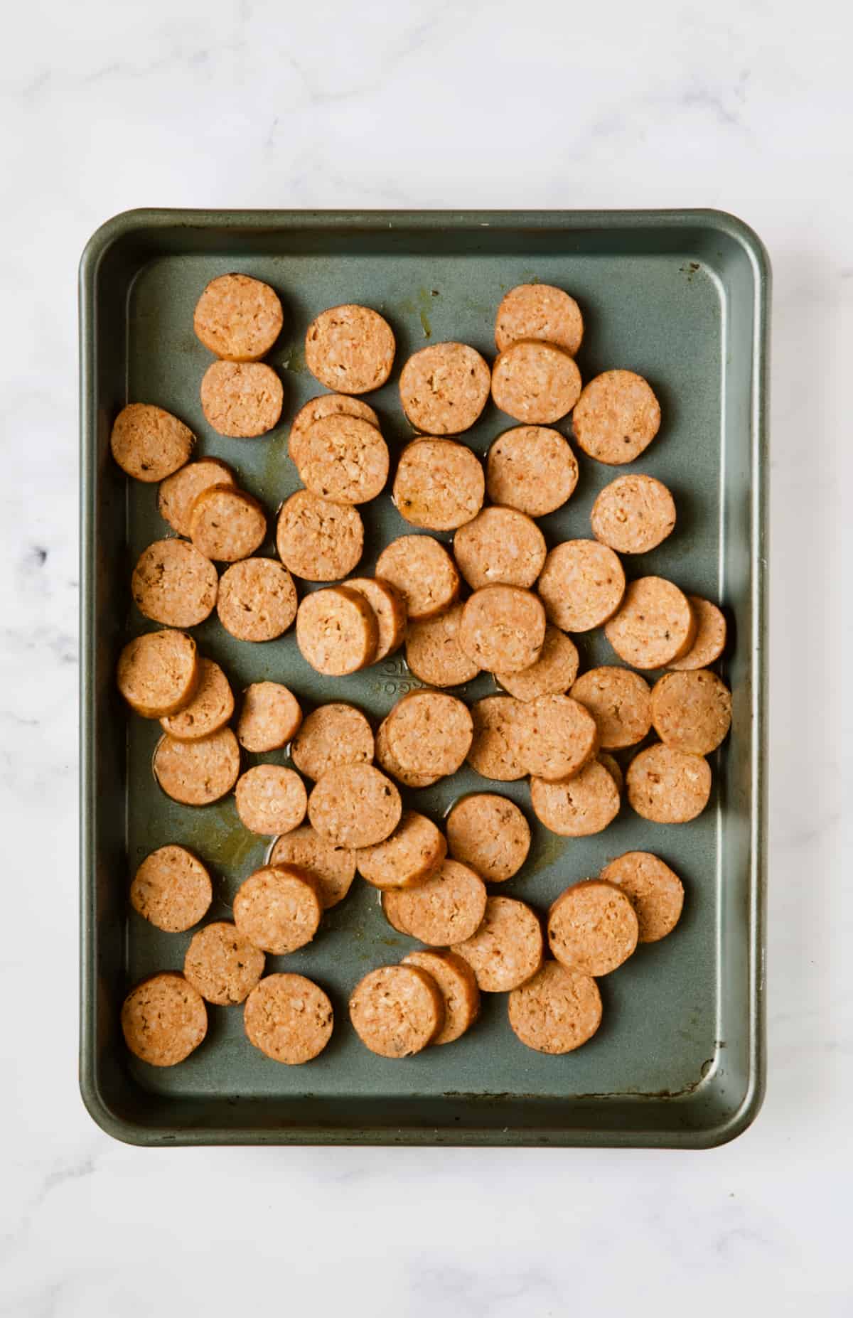 Chorizo slices on baking sheet.