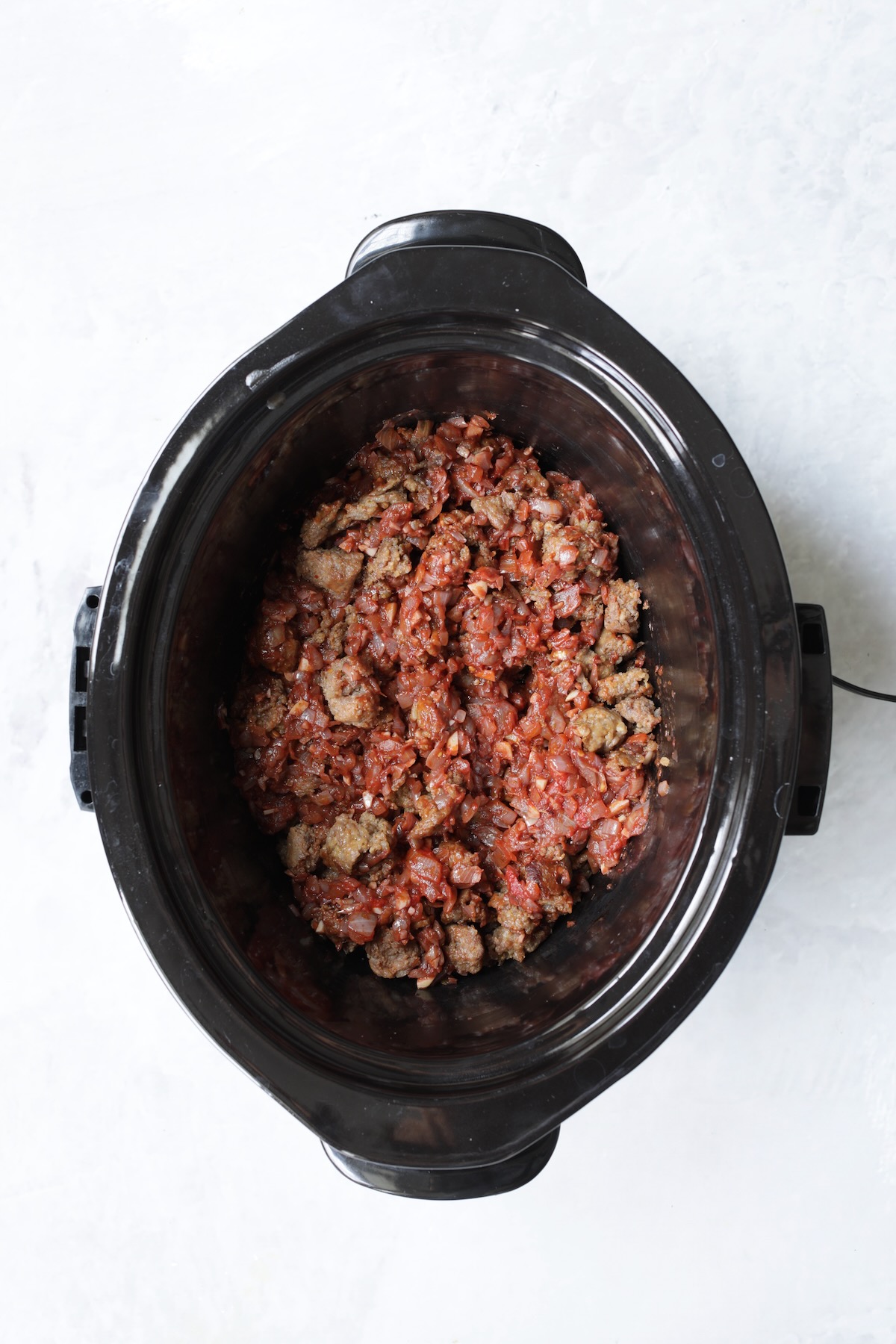 Sausage with onions and red wine in slow cooker.