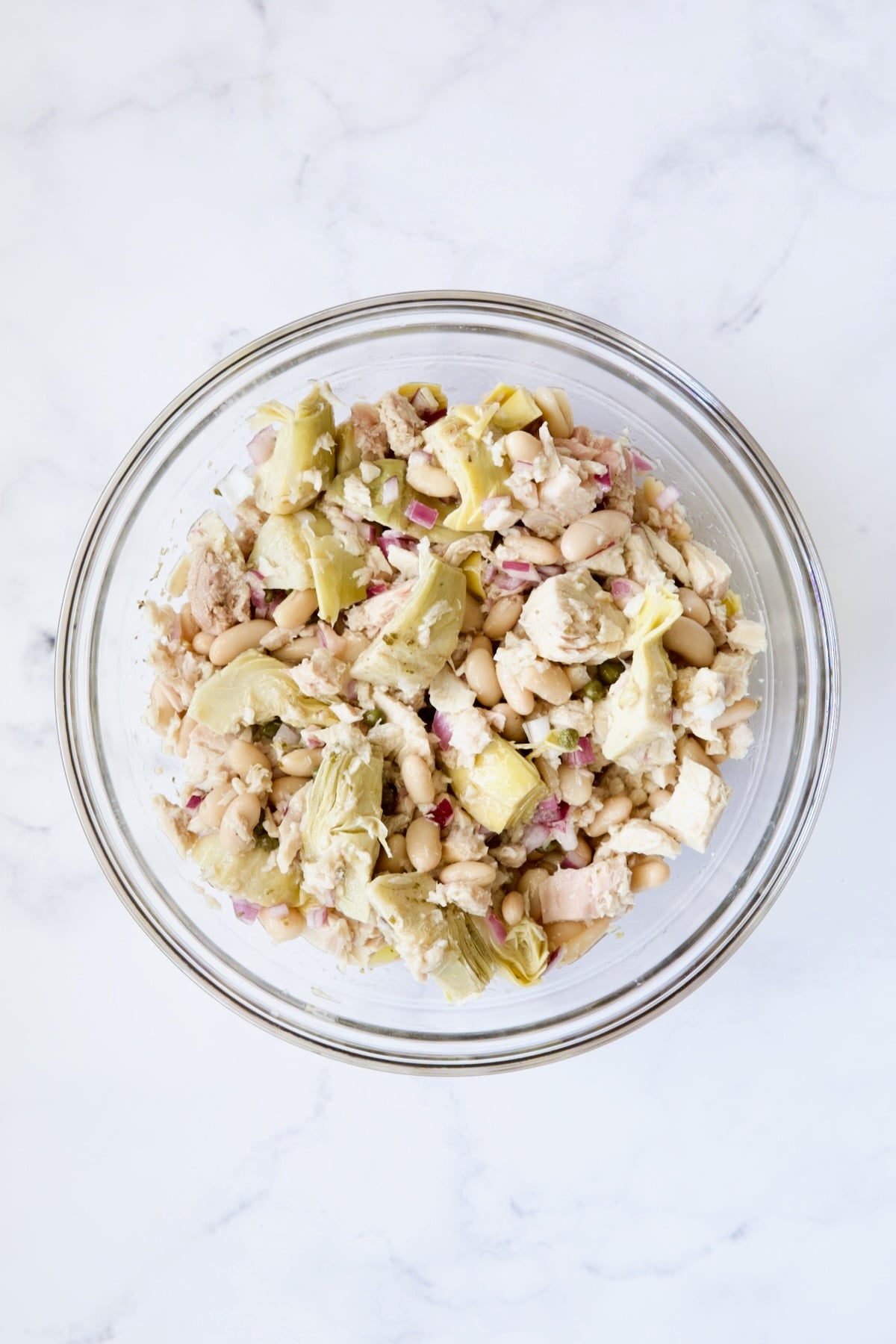 Artichokes, beans and tuna in glass bowl.