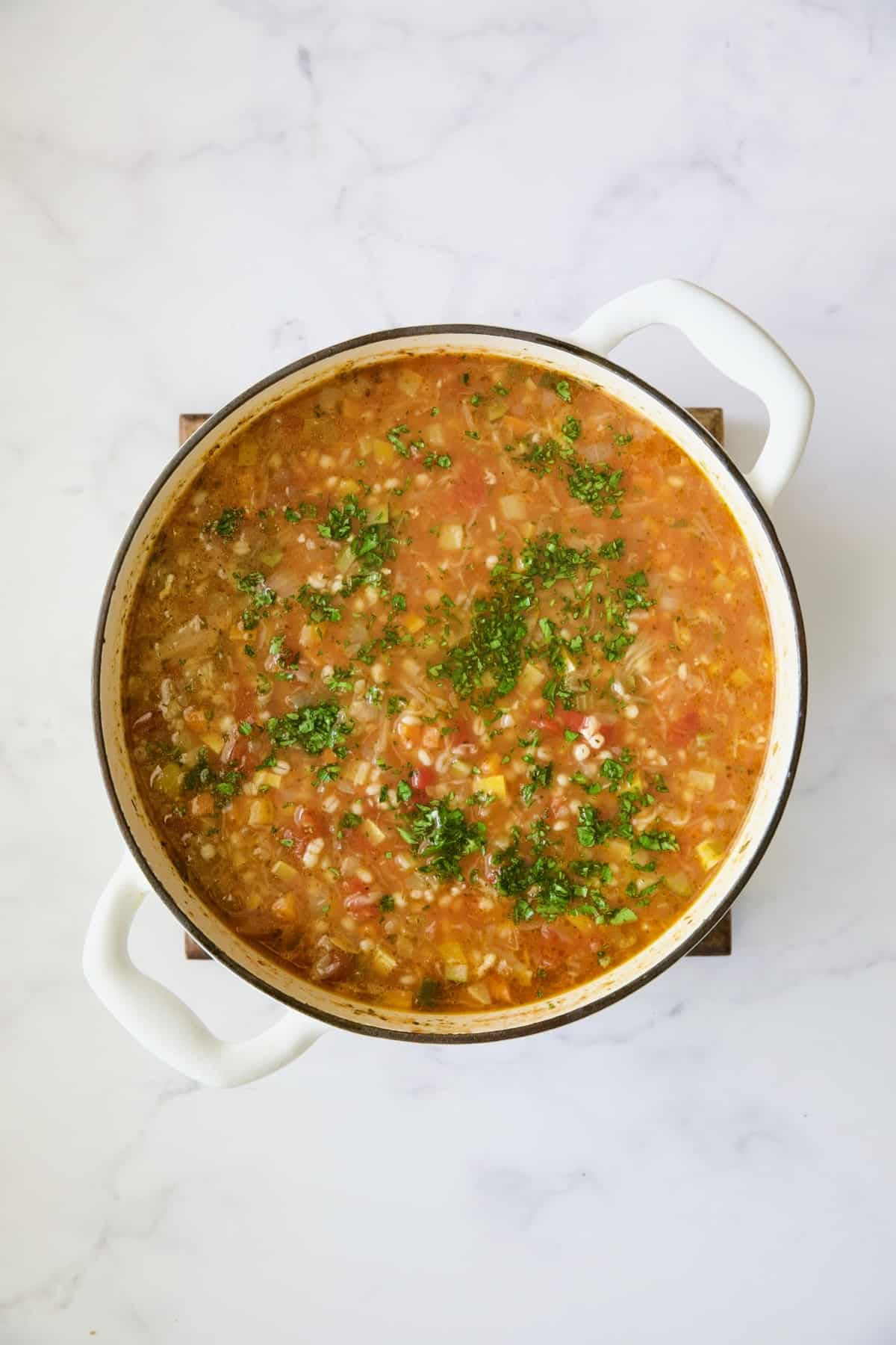 Vegetable Barley Soup with fresh parsley added after being cooked.