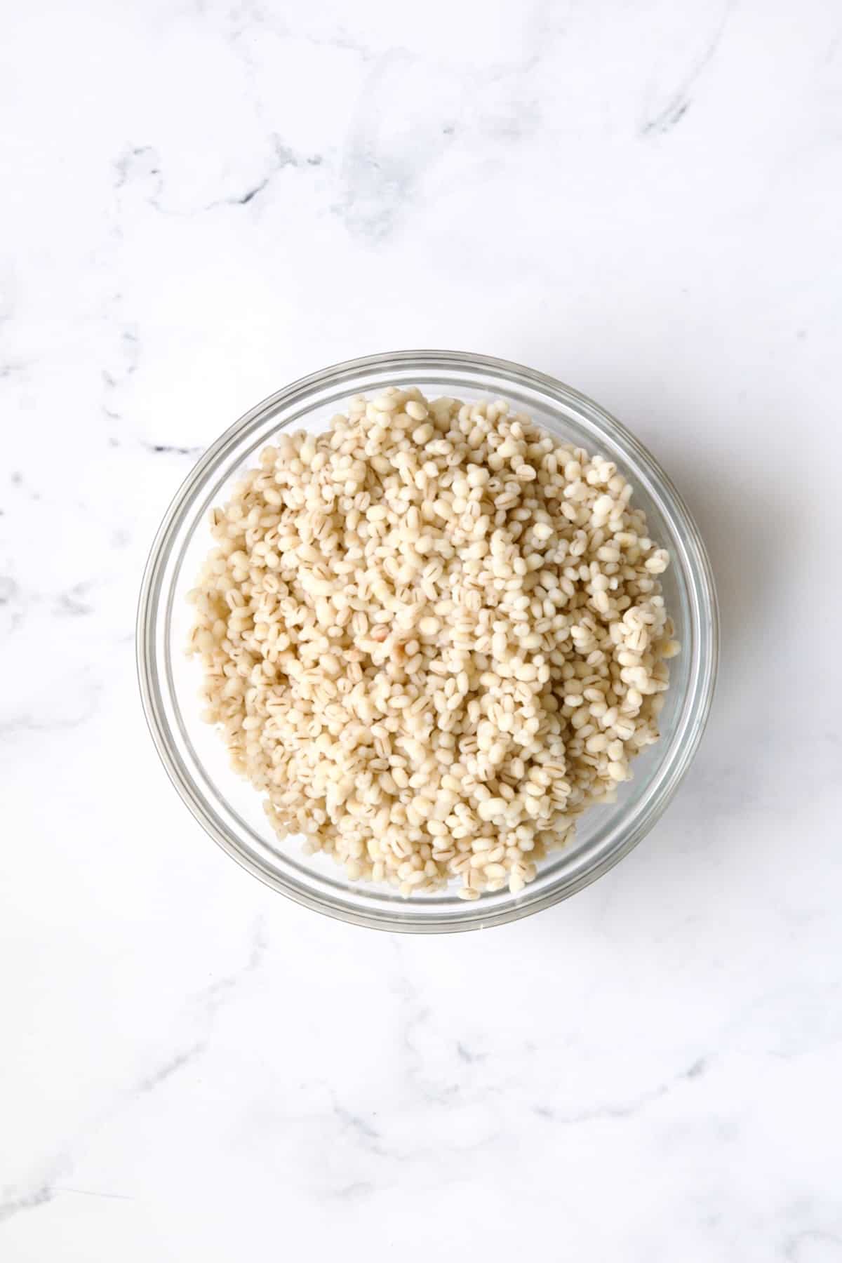 Bowl of cooked barley in glass bowl.