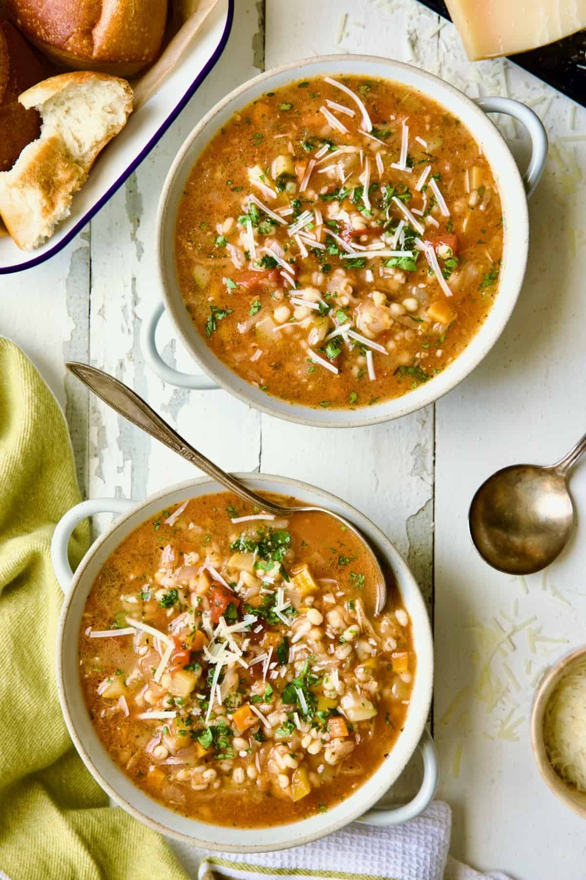 Two bowls of Vegetable Barley Soup on white distressed background.