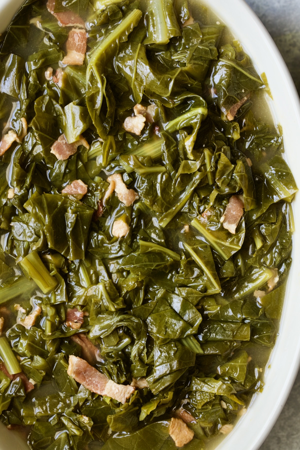Braised Southern Greens in white oval serving bowl.