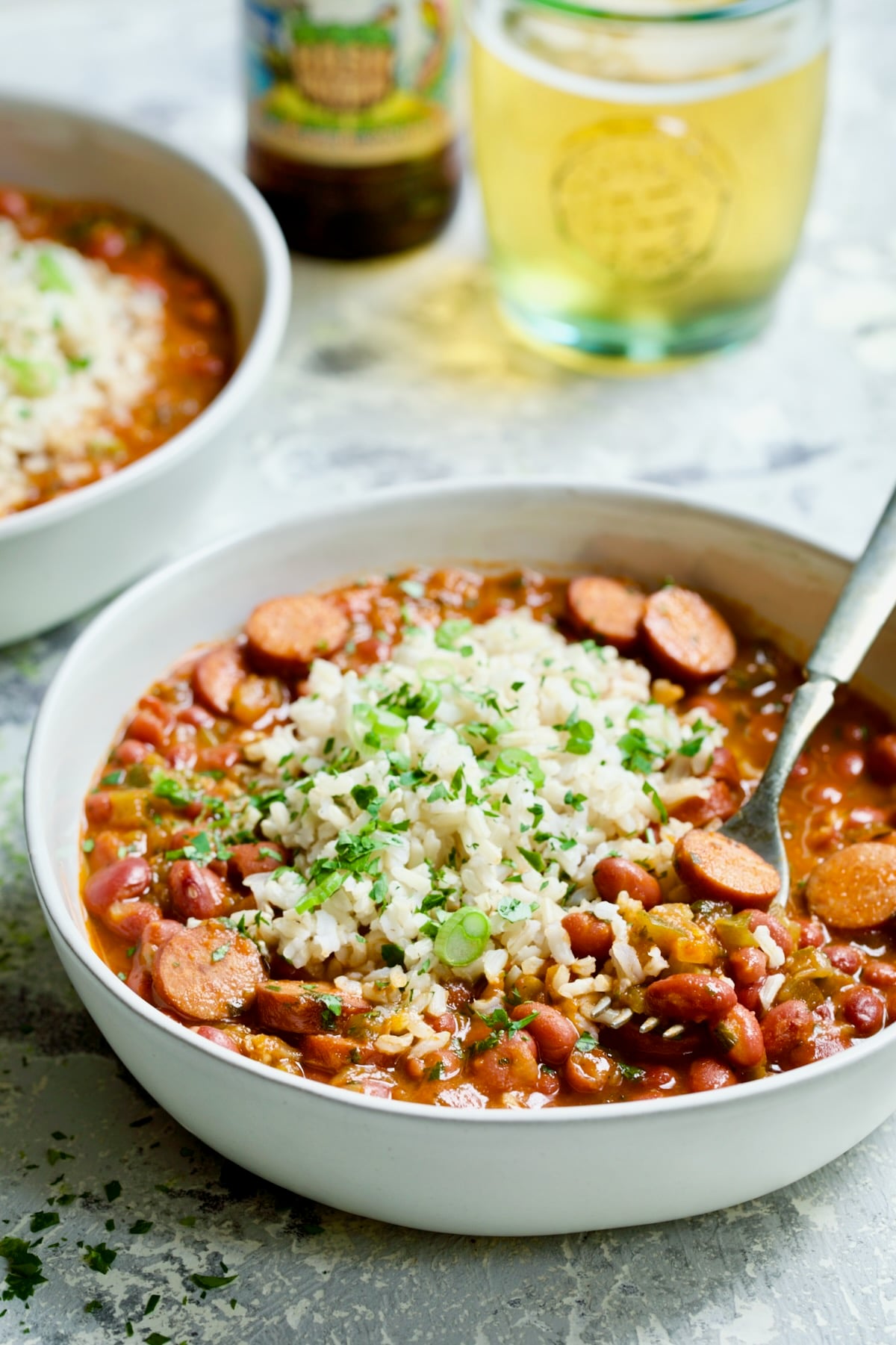 Easy Red Beans and Rice in white bowl with fork garnished with fresh parsley.