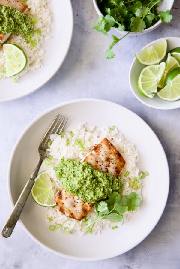 Mahi-Mahi with Cilantro - Ginger Pesto with jasmine rice on white plate garnished with lime wedge and cilantro.