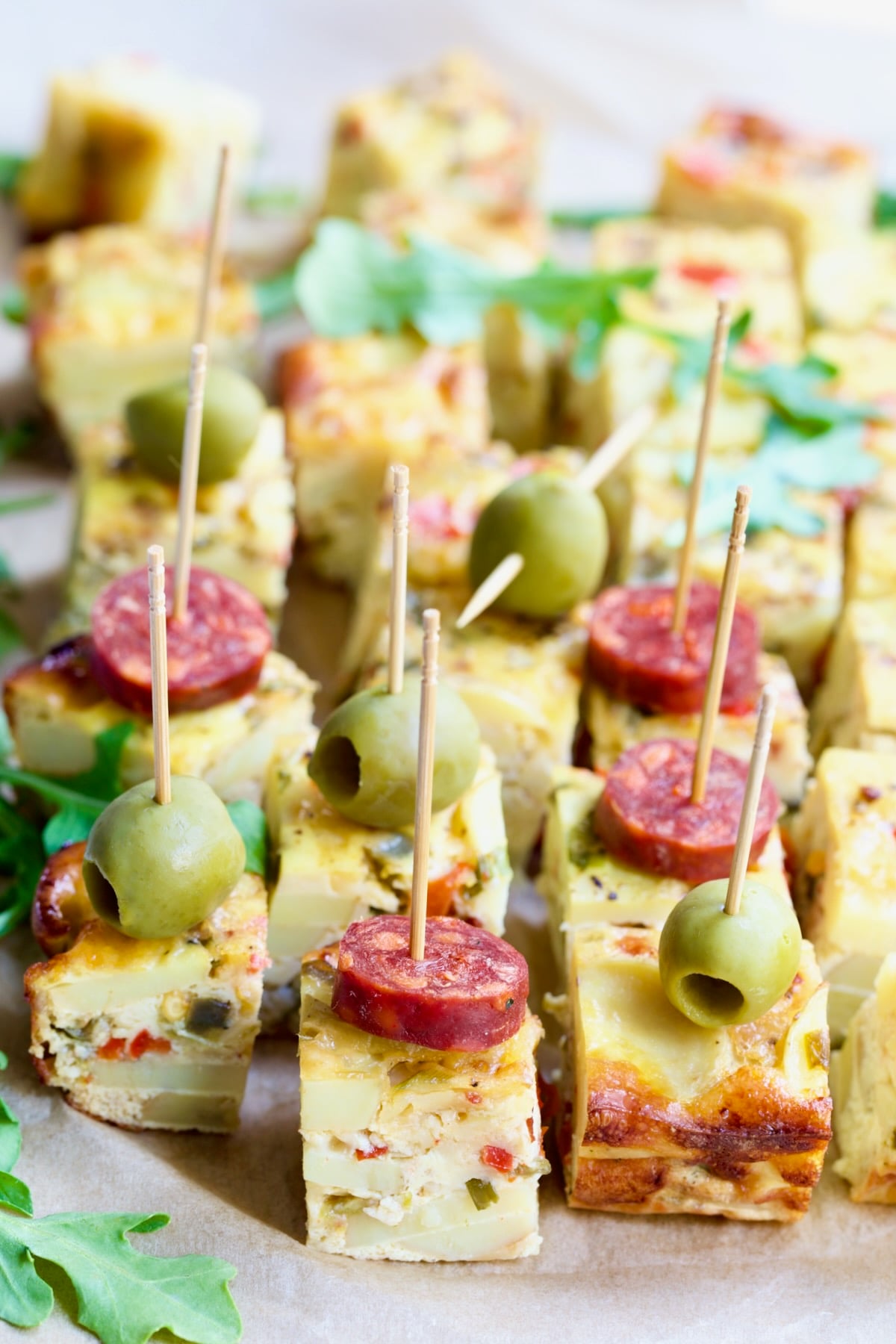 Cubes of Oven-Baked Spanish Tortilla garnished with chorizo and olives.
