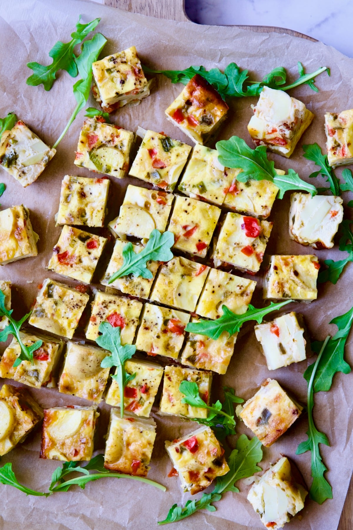 Oven-Baked Spanish Tortilla on cutting board garnished with arugula.