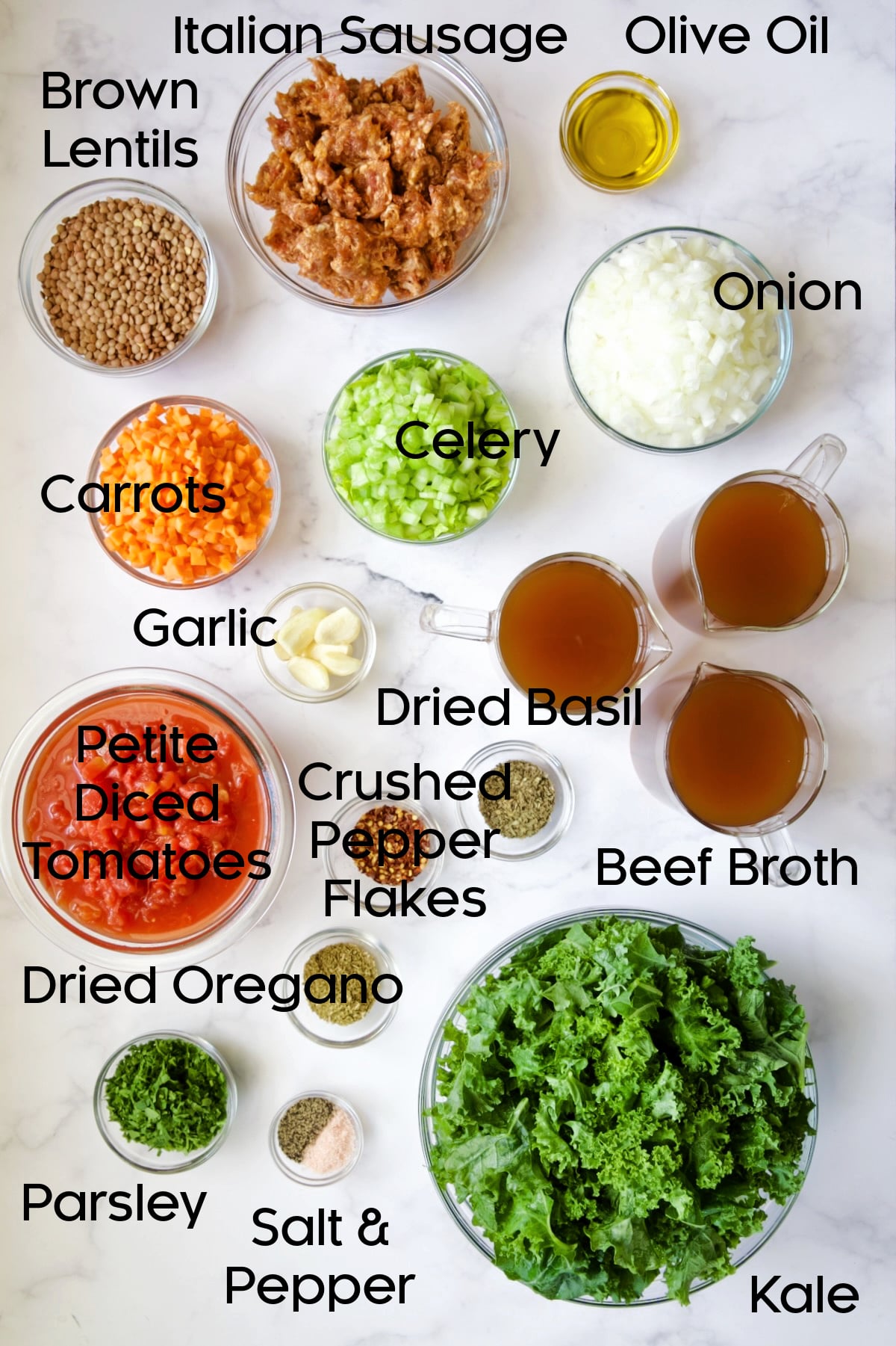 Ingredients for Sausage and Lentil Soup with Kale in glass bowls.
