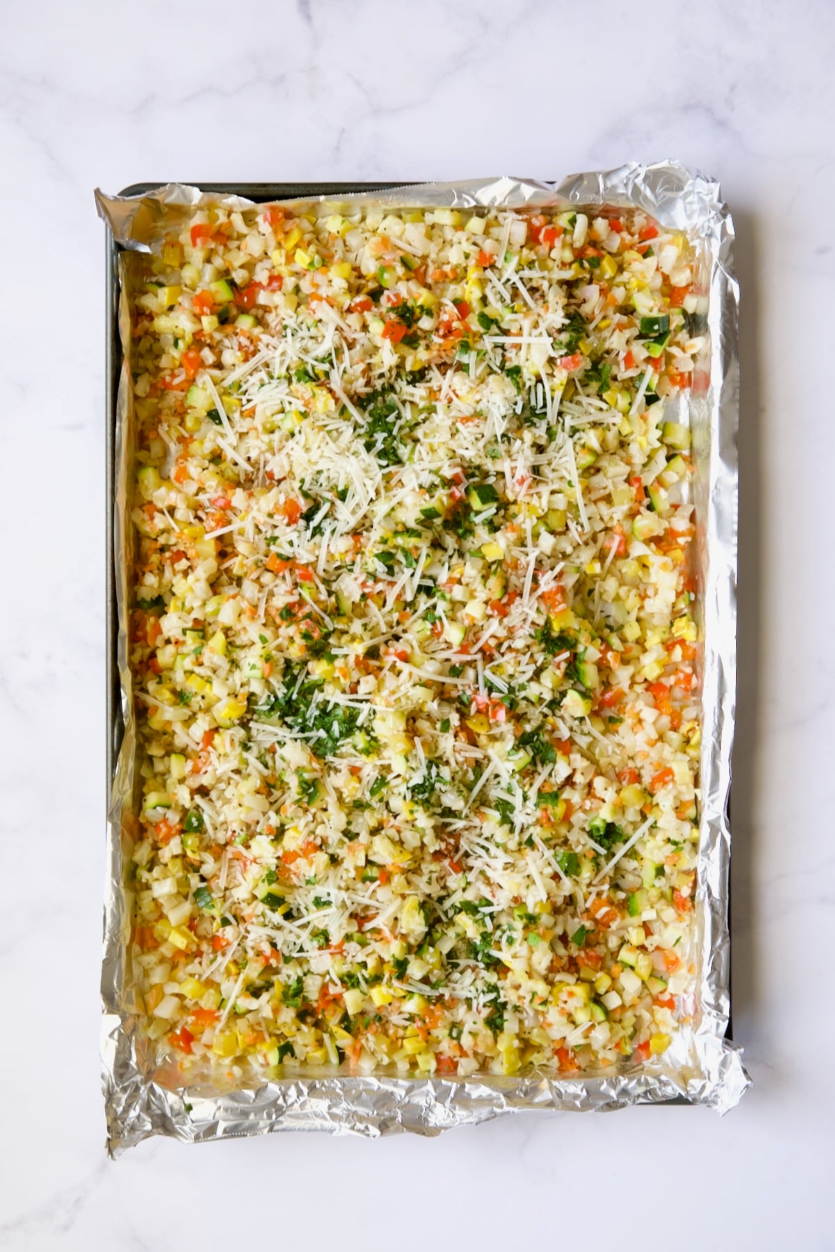 Garlic Parmesan Roasted Vegetable Rice on aluminum foil-lined sheetpan.