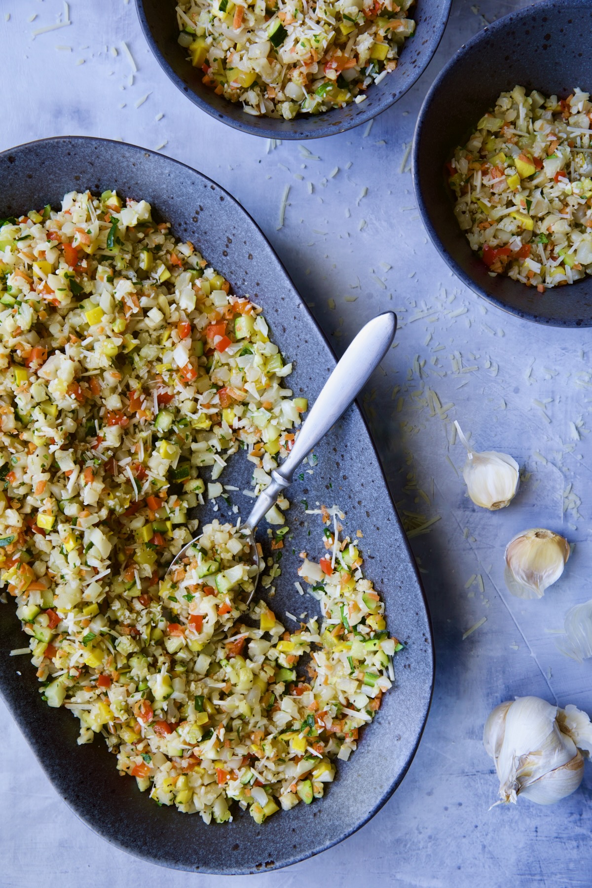 Garlic Parmesan Roasted Vegetable Rice on platter with it being served into two bowls.