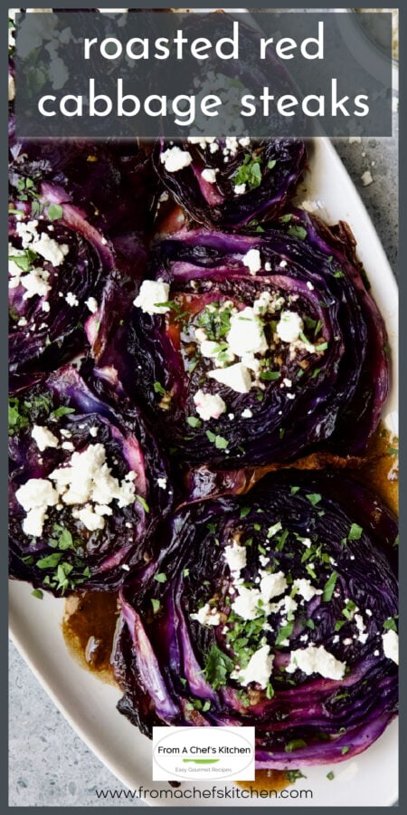 Roasted red cabbage steaks on white oval platter garnished with goat cheese and chopped parsley.