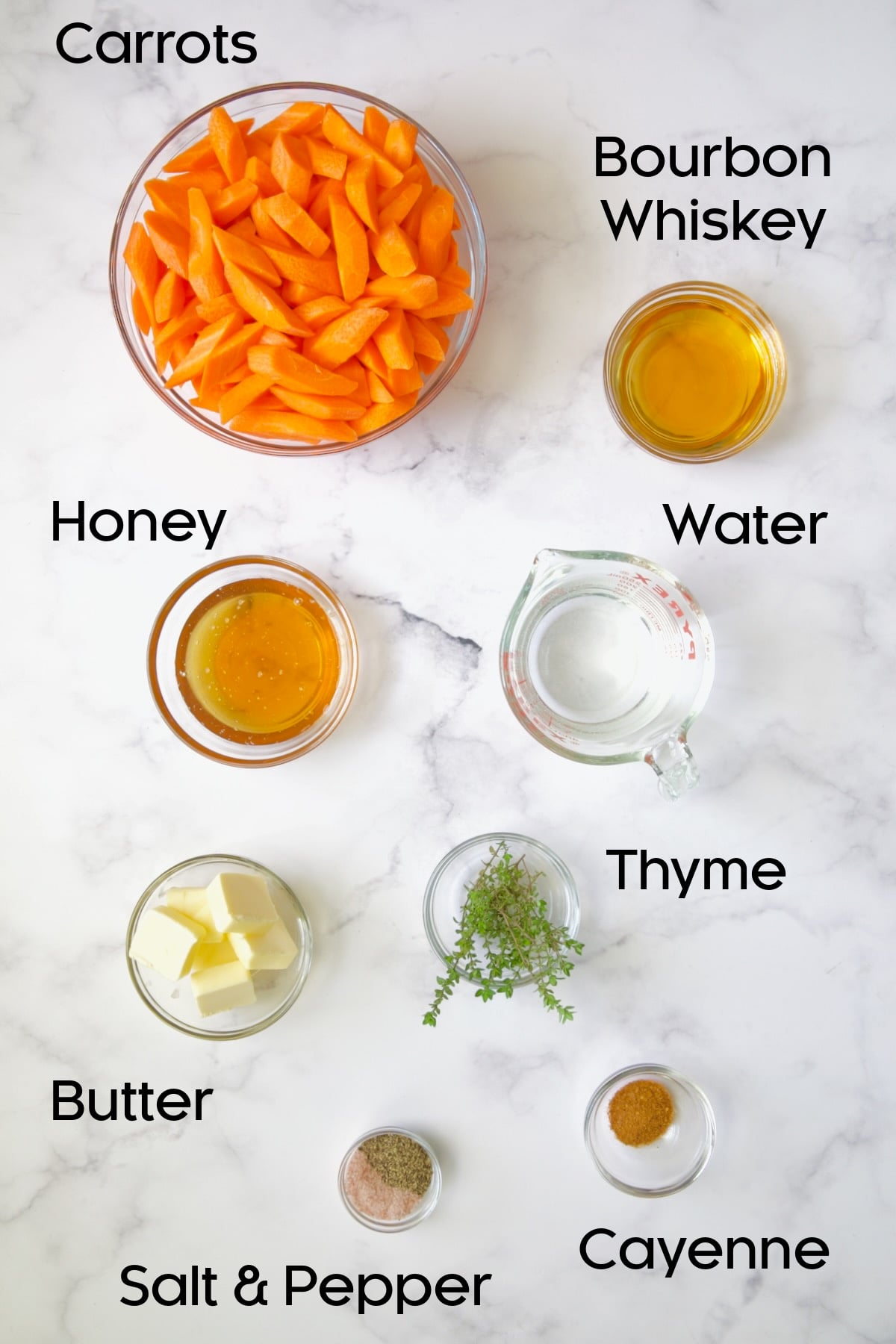 Ingredients for Bourbon-Glazed Carrots with Honey in glass bowls.