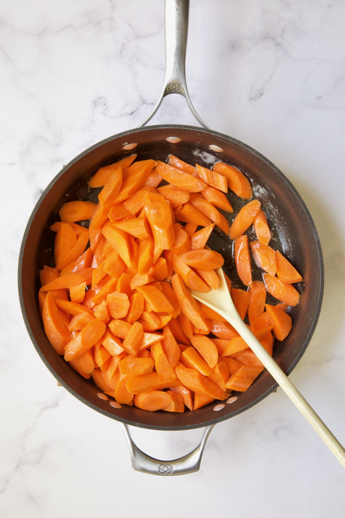 Carrots being sauteed in butter in nonstick skillet.