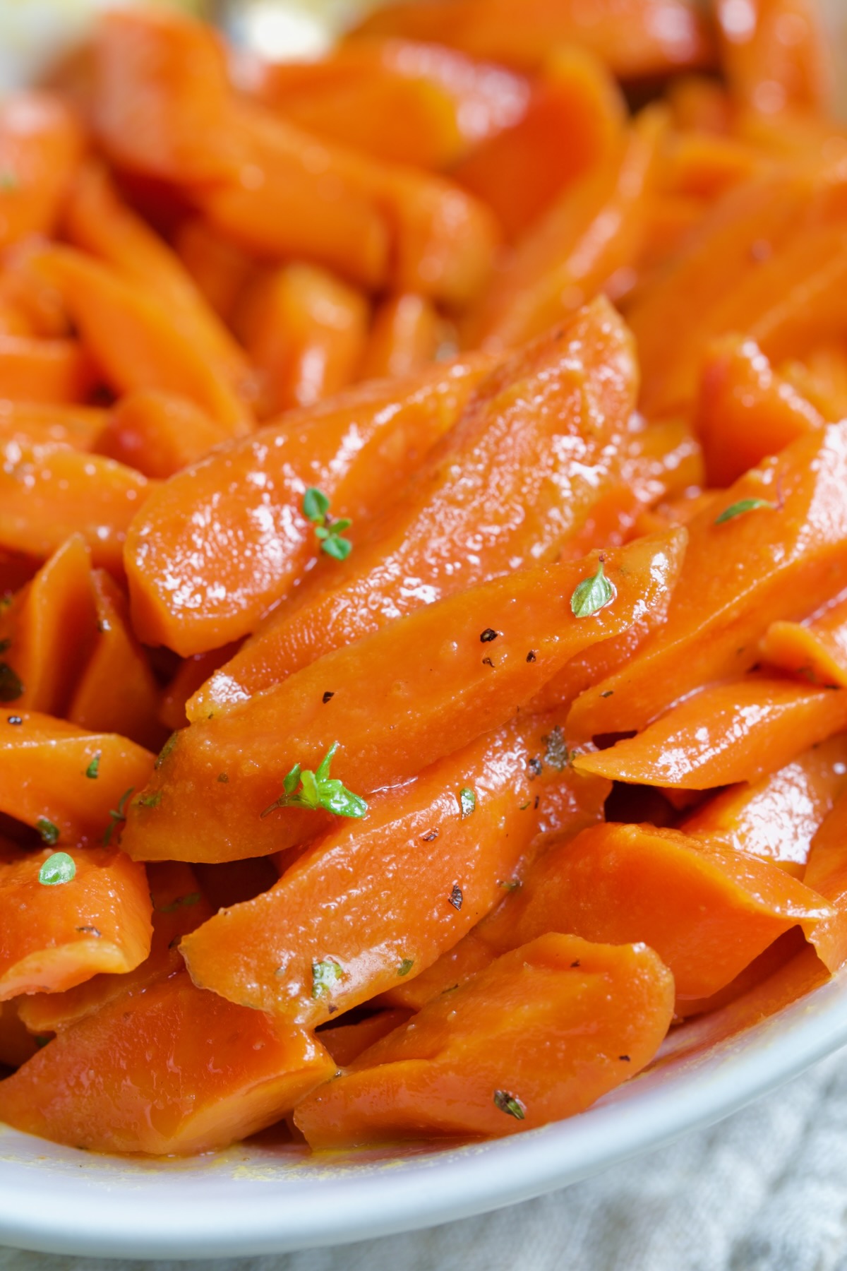 Bourbon-Glazed Carrots with Honey in white serving bowl.
