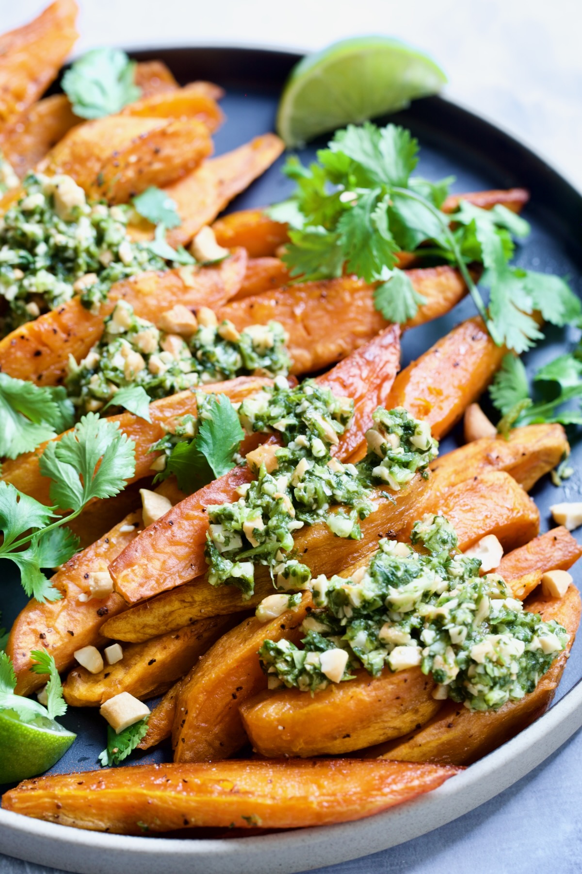 Roasted Sweet Potato Wedges with Cilantro - Cashew Sauce on black plate.
