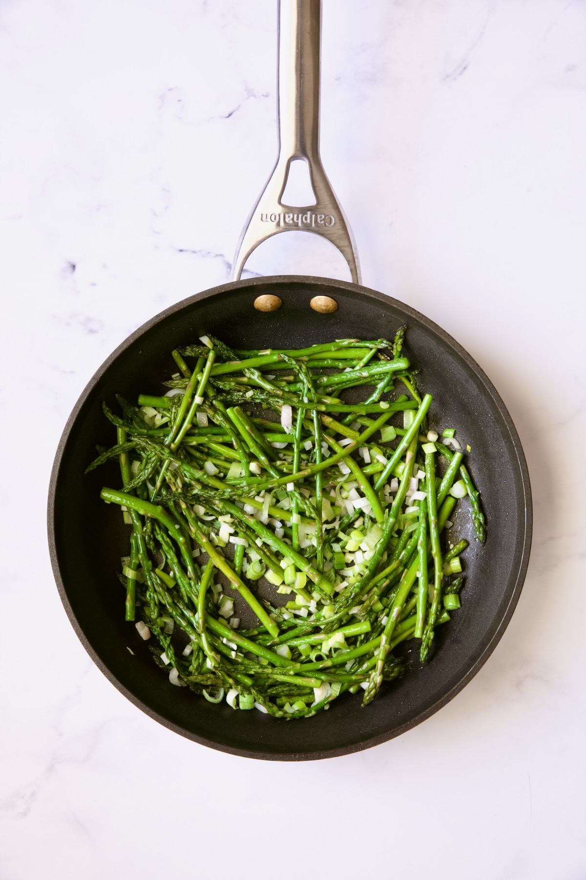 Cooked asparagus and scallions in nonstick skillet.