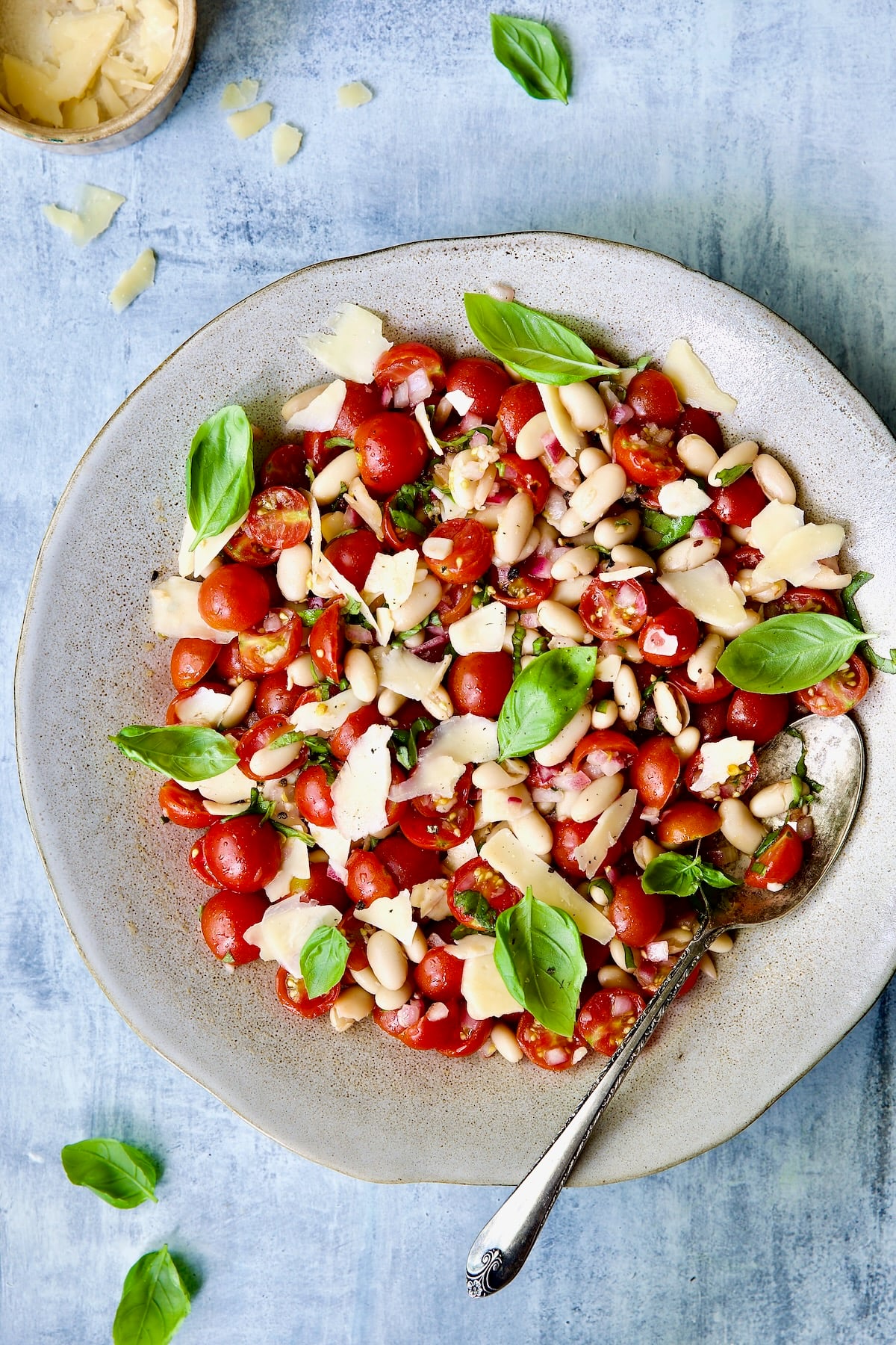 Tuscan Cherry Tomato and White Bean Salad in serving bowl garnished with fresh basil.